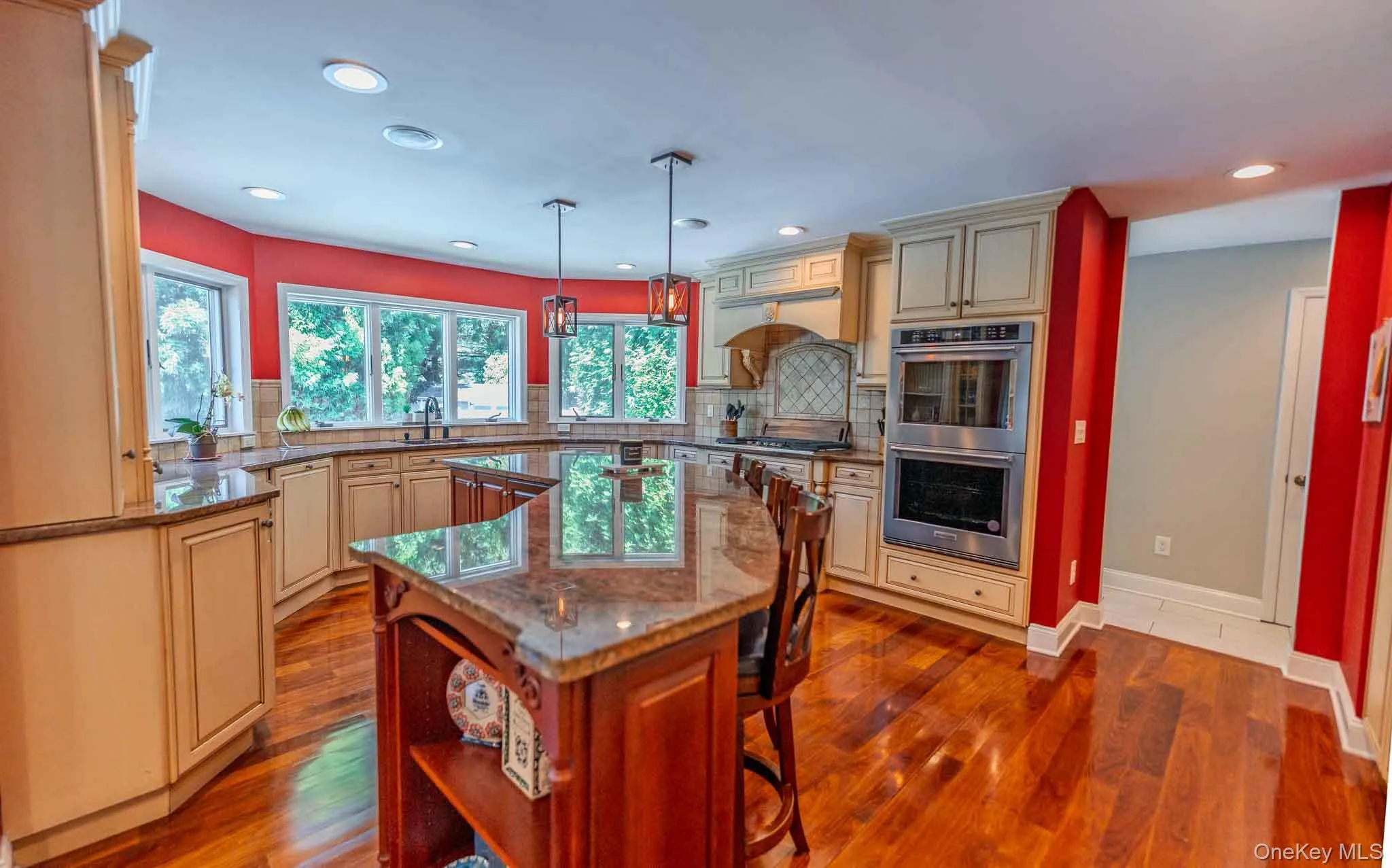 Chef's dream kitchen showcasing custom cabinetry, magnificent granite countertops, and a massive center island with seating. Equipped with premium stainless steel appliances—including a gas stove and brand-new double wall ovens—plus a convenient wet bar and waste disposal. Chef's dream kitchen showcasing custom cabinetry, magnificent granite countertops, and a massive center island with seating. Equipped with premium stainless steel appliances—including a gas stove and brand-new double wall ovens—plus a convenient wet bar and waste disposal.