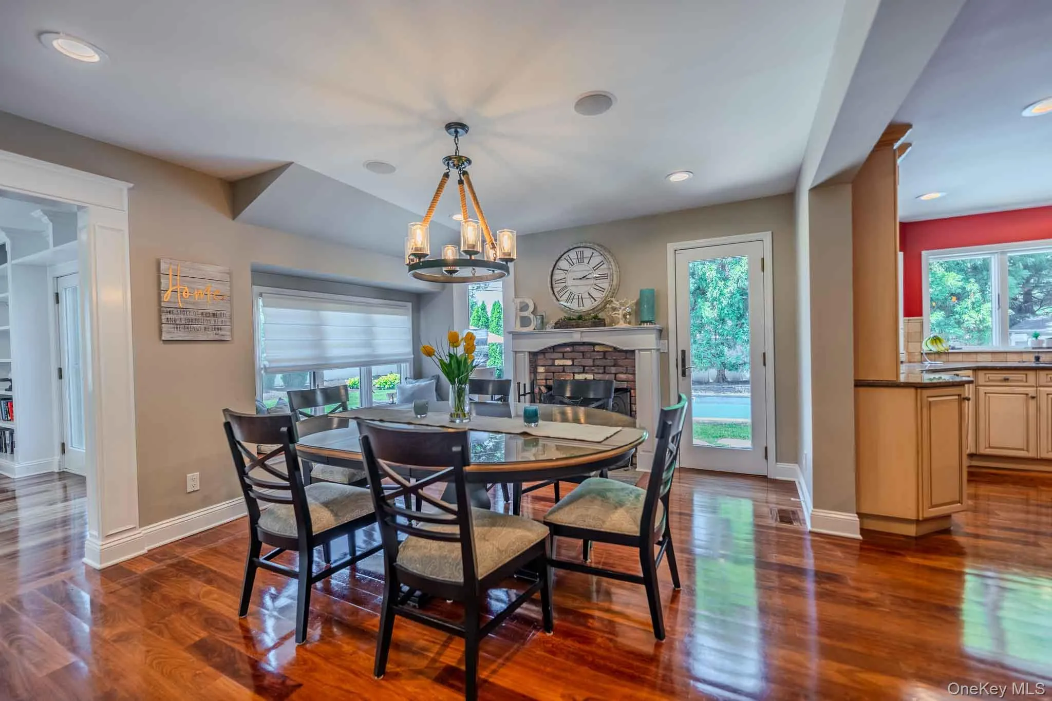 Sophisticated open-concept dining area, perfectly positioned right next to a cozy rustic red brick fireplace and mantel. Sophisticated open-concept dining area, perfectly positioned right next to a cozy rustic red brick fireplace and mantel.
