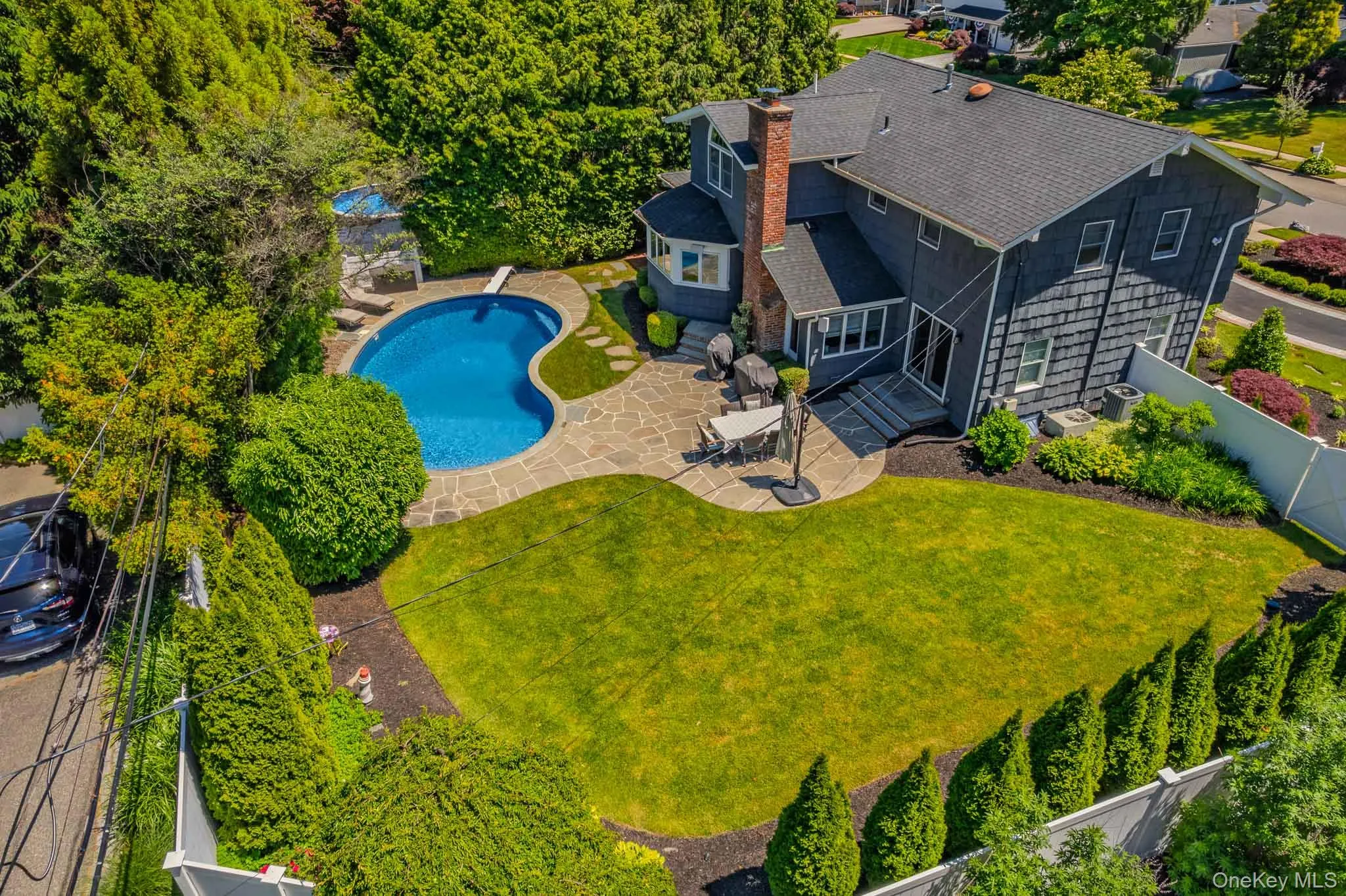 Magnificent backyard oasis featuring a pristine in-ground pool, expansive stone patio perfect for outdoor dining, and a beautifully manicured, private lawn framed by mature privacy hedges. Magnificent backyard oasis featuring a pristine in-ground pool, expansive stone patio perfect for outdoor dining, and a beautifully manicured, private lawn framed by mature privacy hedges.