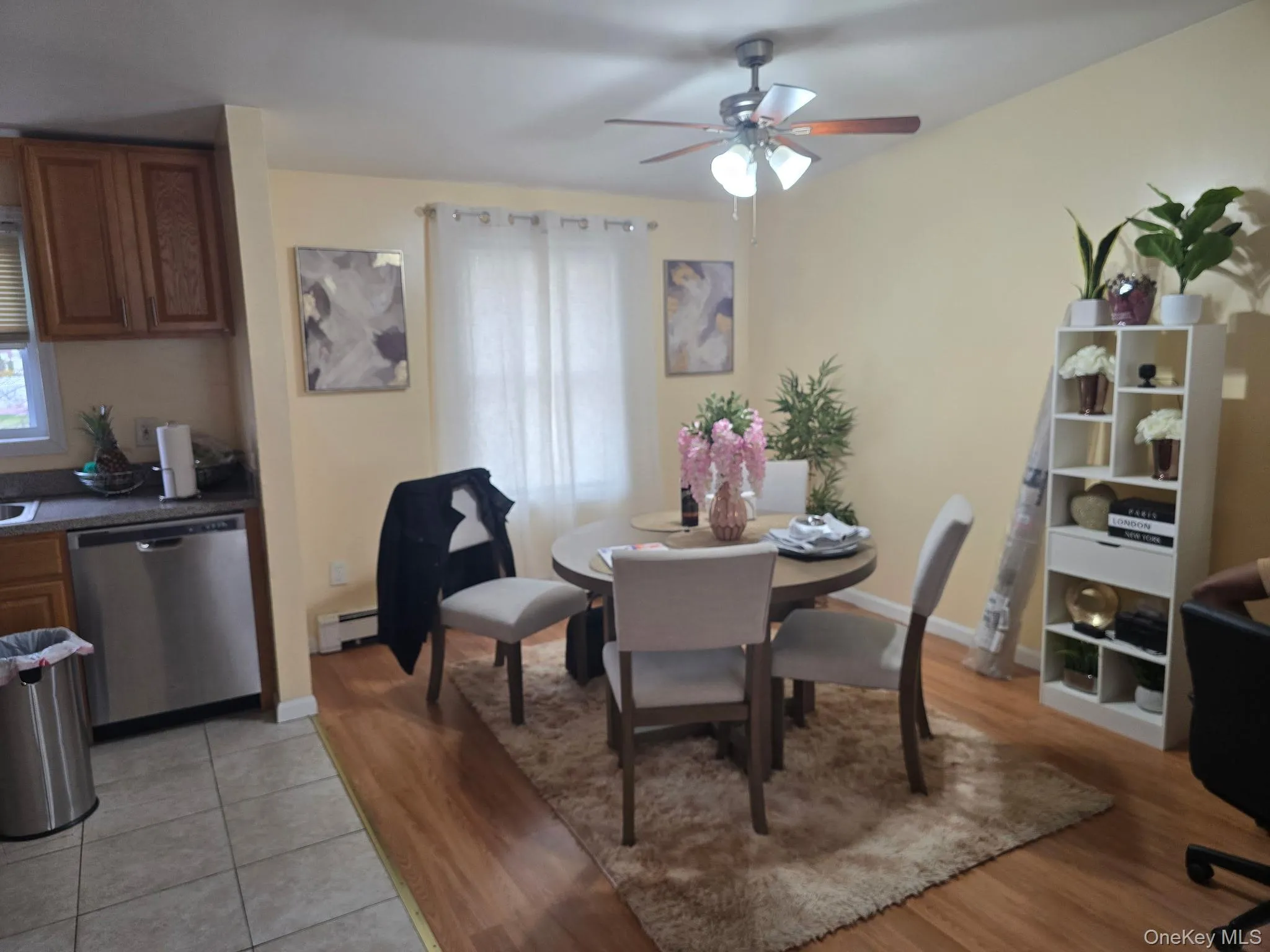 Dining room featuring light wood finished floors, ceiling fan, baseboard heating, and plenty of natural light Dining room featuring light wood finished floors, ceiling fan, baseboard heating, and plenty of natural light