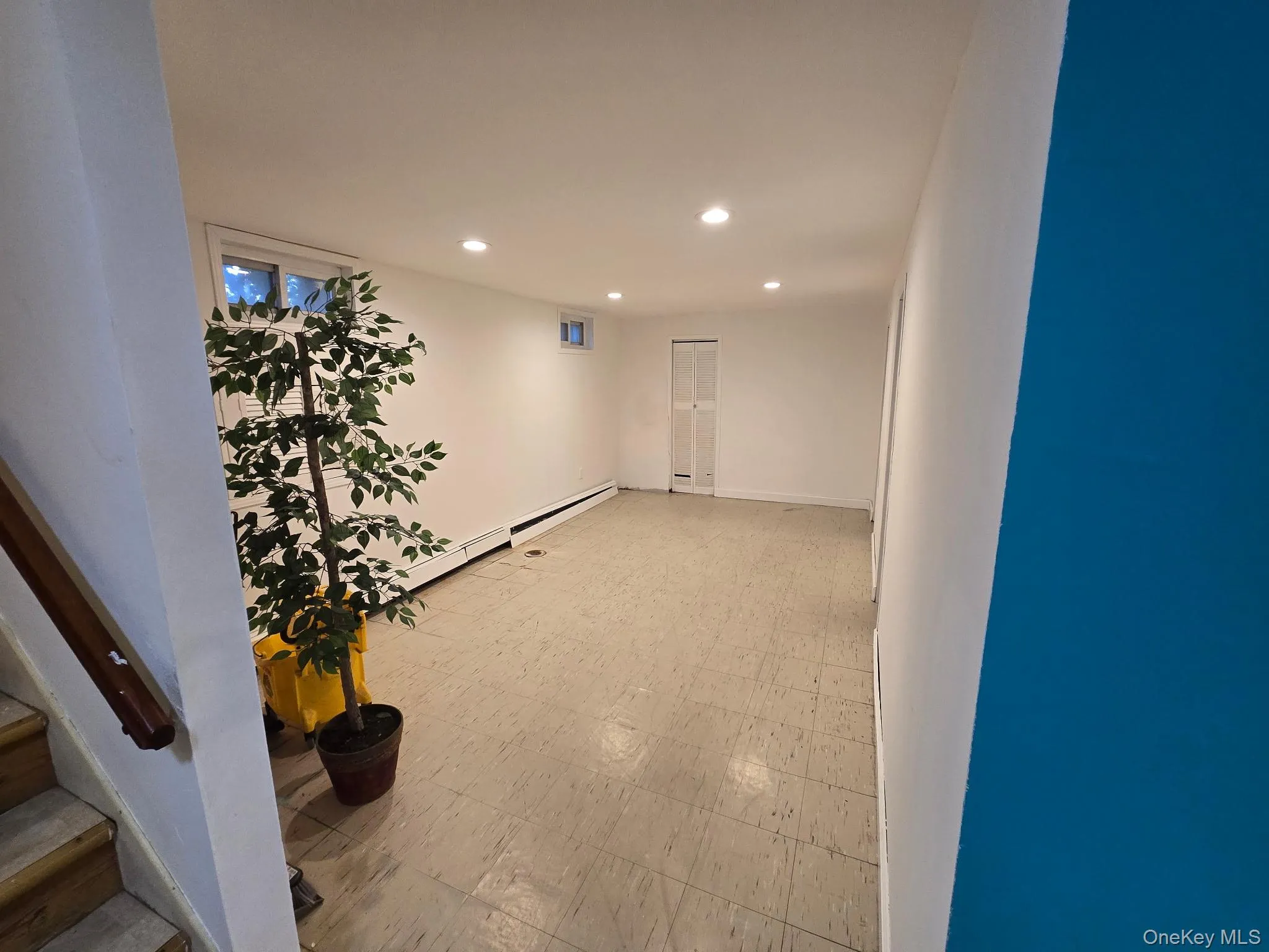 Corridor with light floors, recessed lighting, and a baseboard radiator Corridor with light floors, recessed lighting, and a baseboard radiator