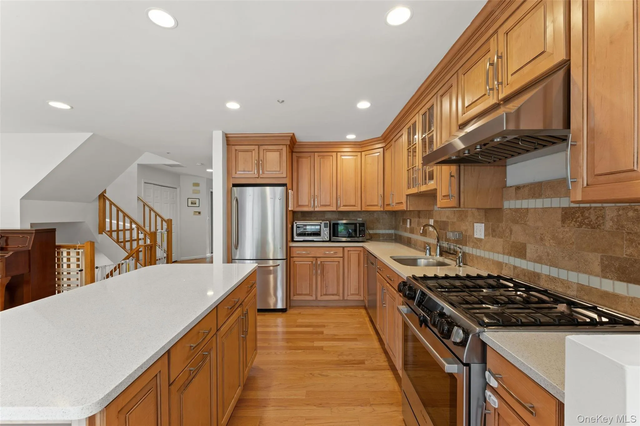 Kitchen featuring wood-finish cabinetry, stainless steel appliances, and a gas range Kitchen featuring wood-finish cabinetry, stainless steel appliances, and a gas range