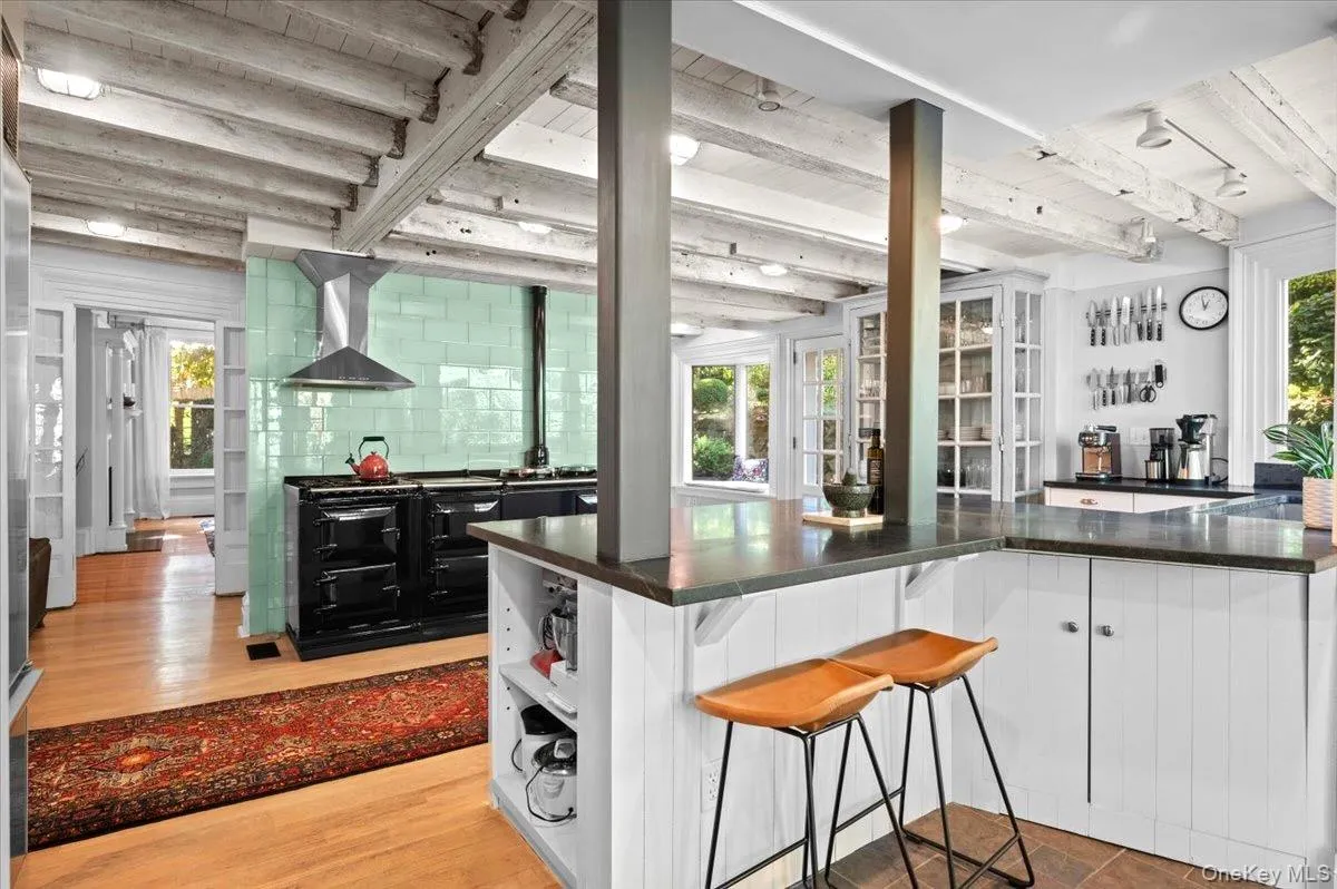 Kitchen with healthy amount of natural light, open shelves, white cabinetry, and a wood ceiling with exposed beams Kitchen with healthy amount of natural light, open shelves, white cabinetry, and a wood ceiling with exposed beams