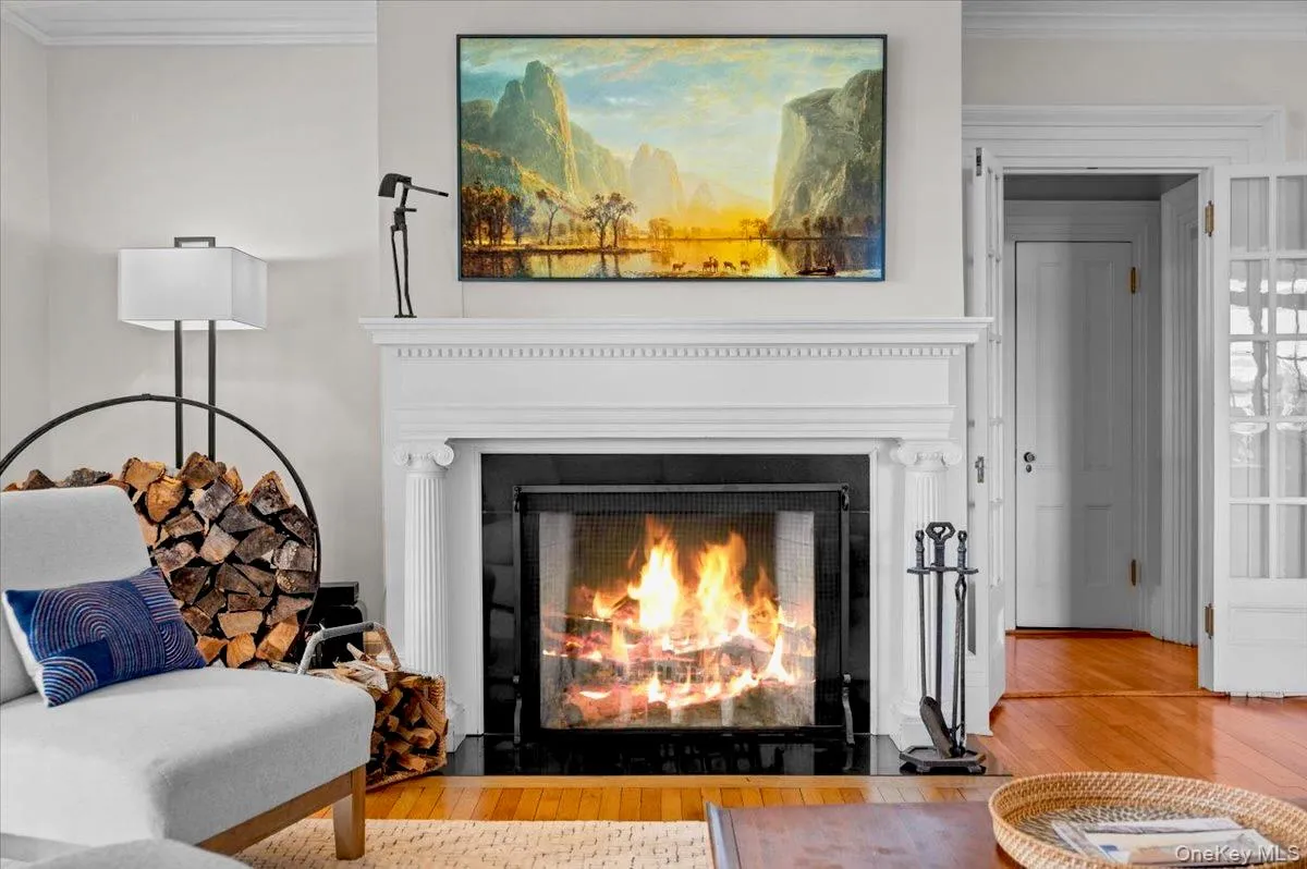 Detailed view of ornamental molding, wood finished floors, and a fireplace Detailed view of ornamental molding, wood finished floors, and a fireplace