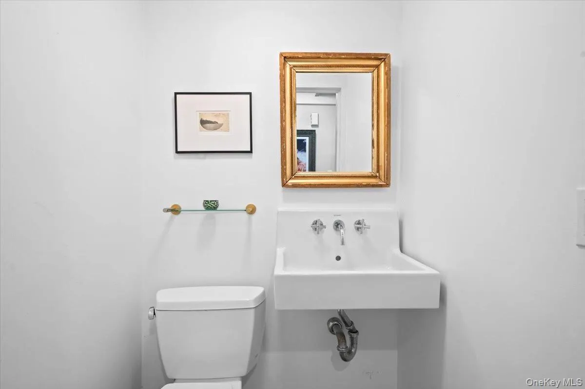 Half bathroom with toilet and a sink Half bathroom with toilet and a sink