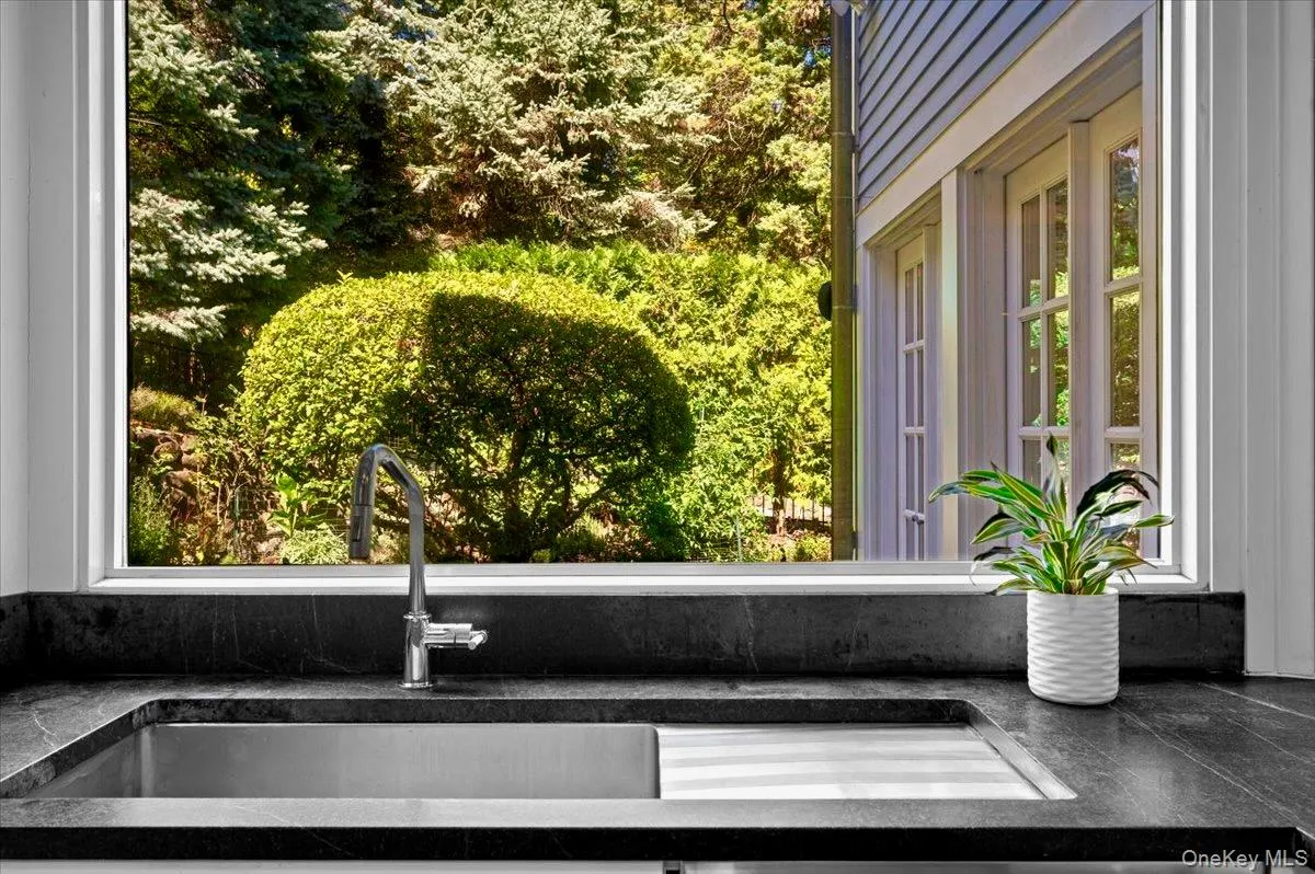 Kitchen view of a sink and dark stone countertops Kitchen view of a sink and dark stone countertops