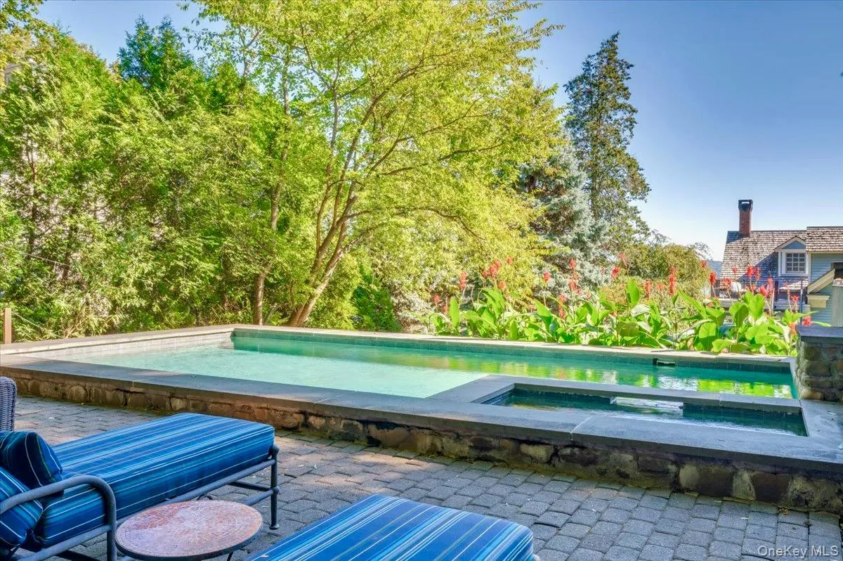 View of swimming pool featuring an in-ground hot tub, a patio area, and a swimming pool View of swimming pool featuring an in-ground hot tub, a patio area, and a swimming pool
