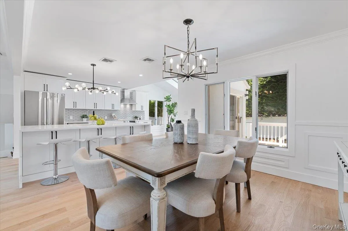 Dining area with a chandelier, light wood-style flooring, recessed lighting, and ornamental molding Dining area with a chandelier, light wood-style flooring, recessed lighting, and ornamental molding