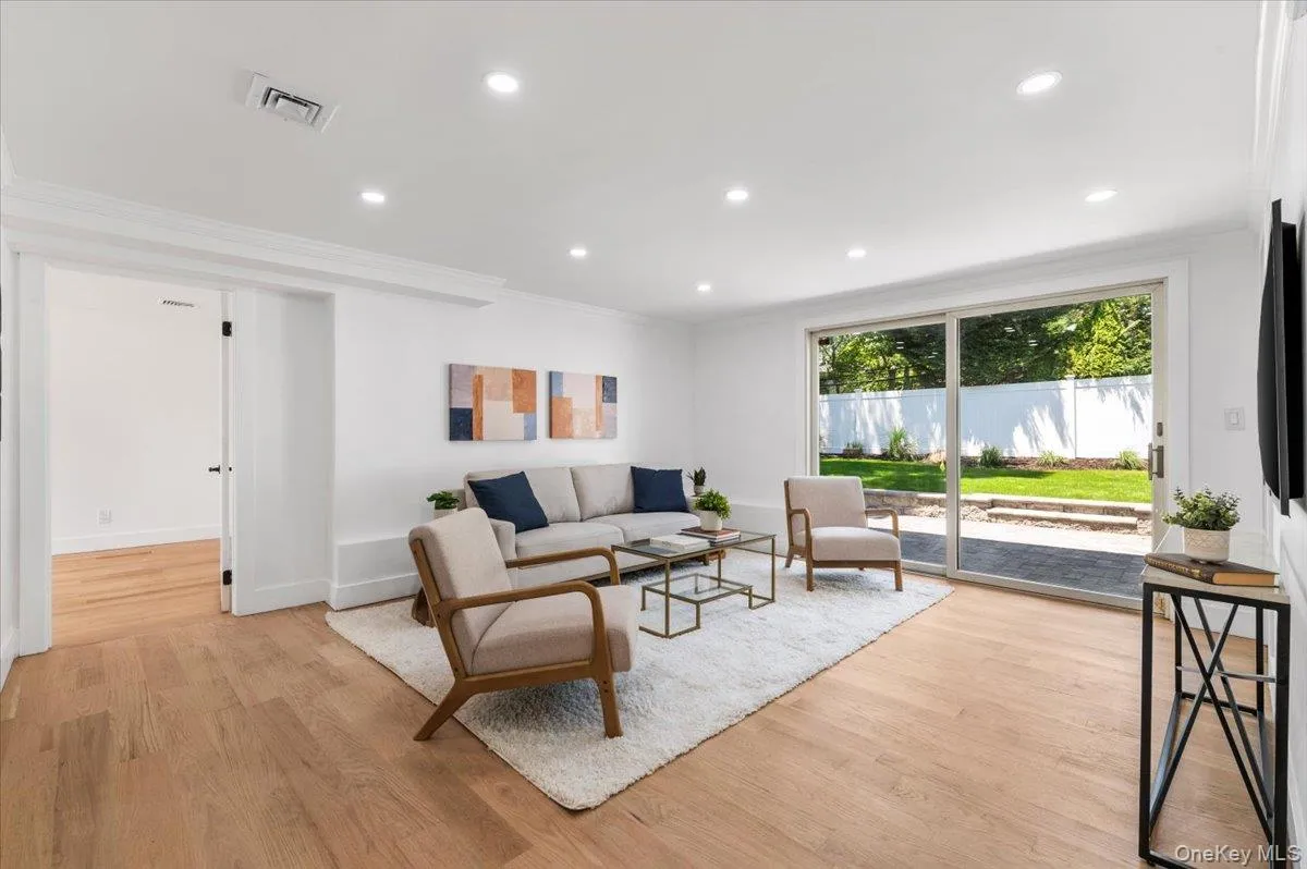Living room with ornamental molding, light wood-style floors, and recessed lighting Living room with ornamental molding, light wood-style floors, and recessed lighting