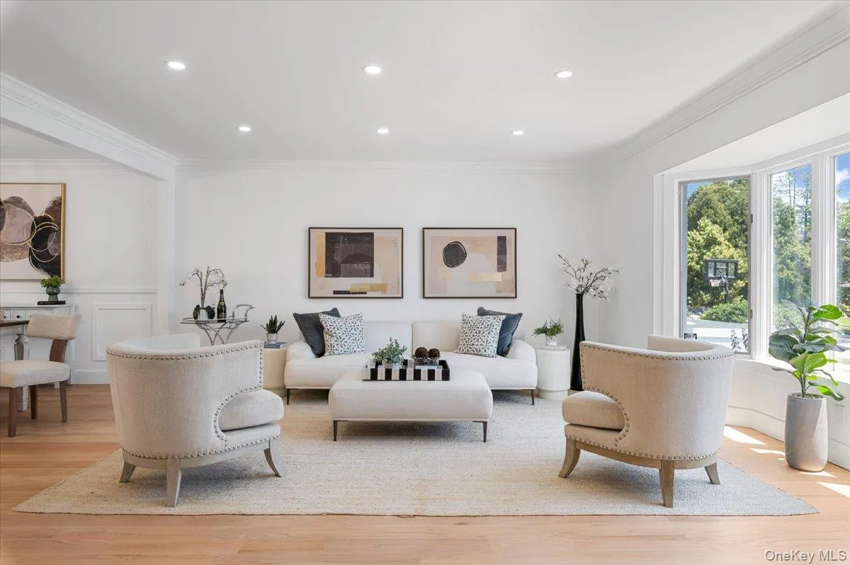Living room featuring crown molding, light wood finished floors, recessed lighting, and wainscoting Living room featuring crown molding, light wood finished floors, recessed lighting, and wainscoting