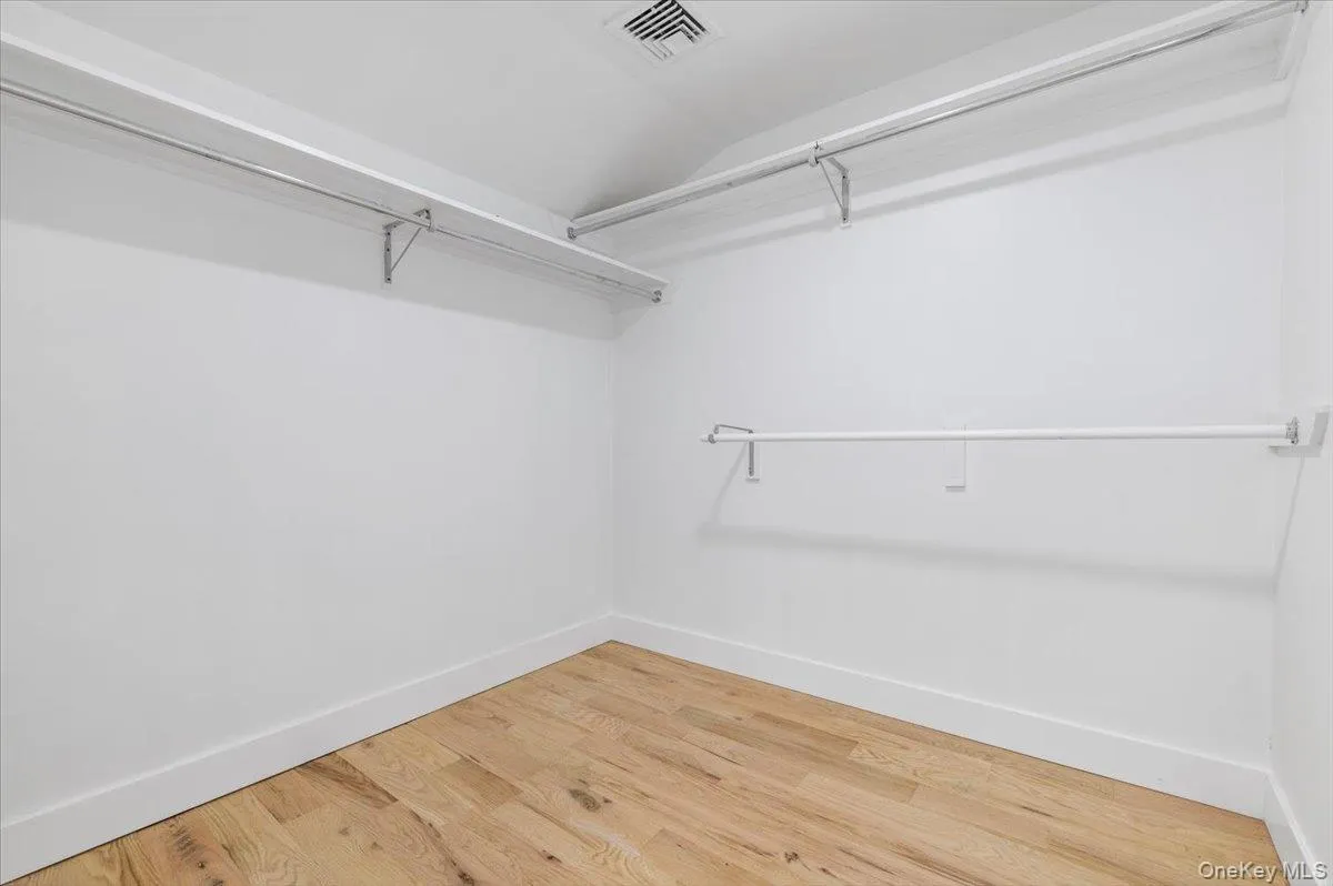 Spacious closet featuring vaulted ceiling and wood finished floors Spacious closet featuring vaulted ceiling and wood finished floors