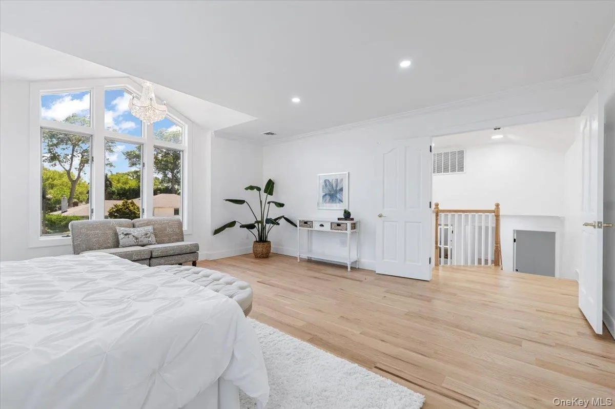 Bedroom featuring ornamental molding, wood finished floors, a chandelier, and recessed lighting Bedroom featuring ornamental molding, wood finished floors, a chandelier, and recessed lighting