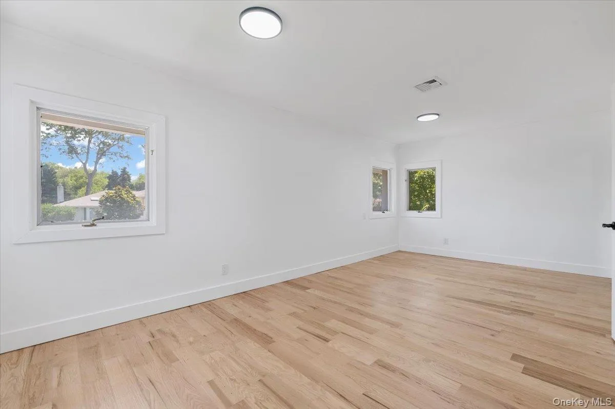 Unfurnished room featuring light wood-type flooring and baseboards Unfurnished room featuring light wood-type flooring and baseboards
