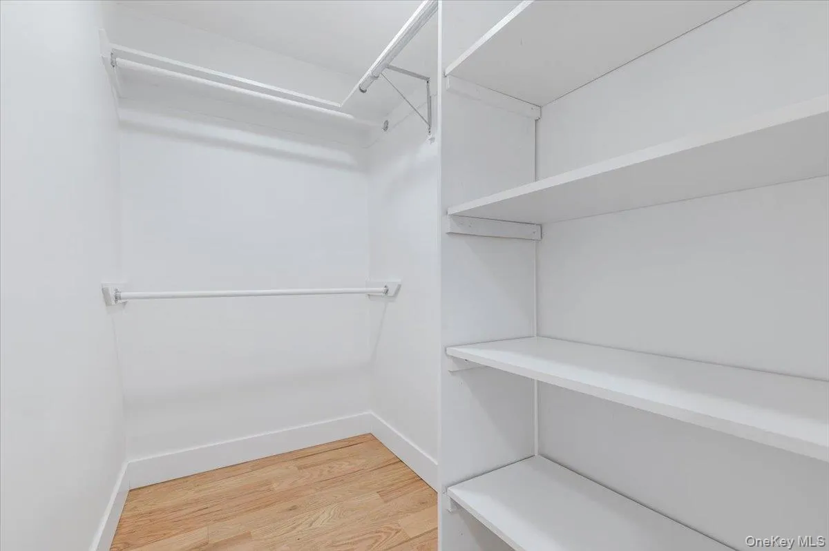 Walk in closet with light wood-type flooring Walk in closet with light wood-type flooring