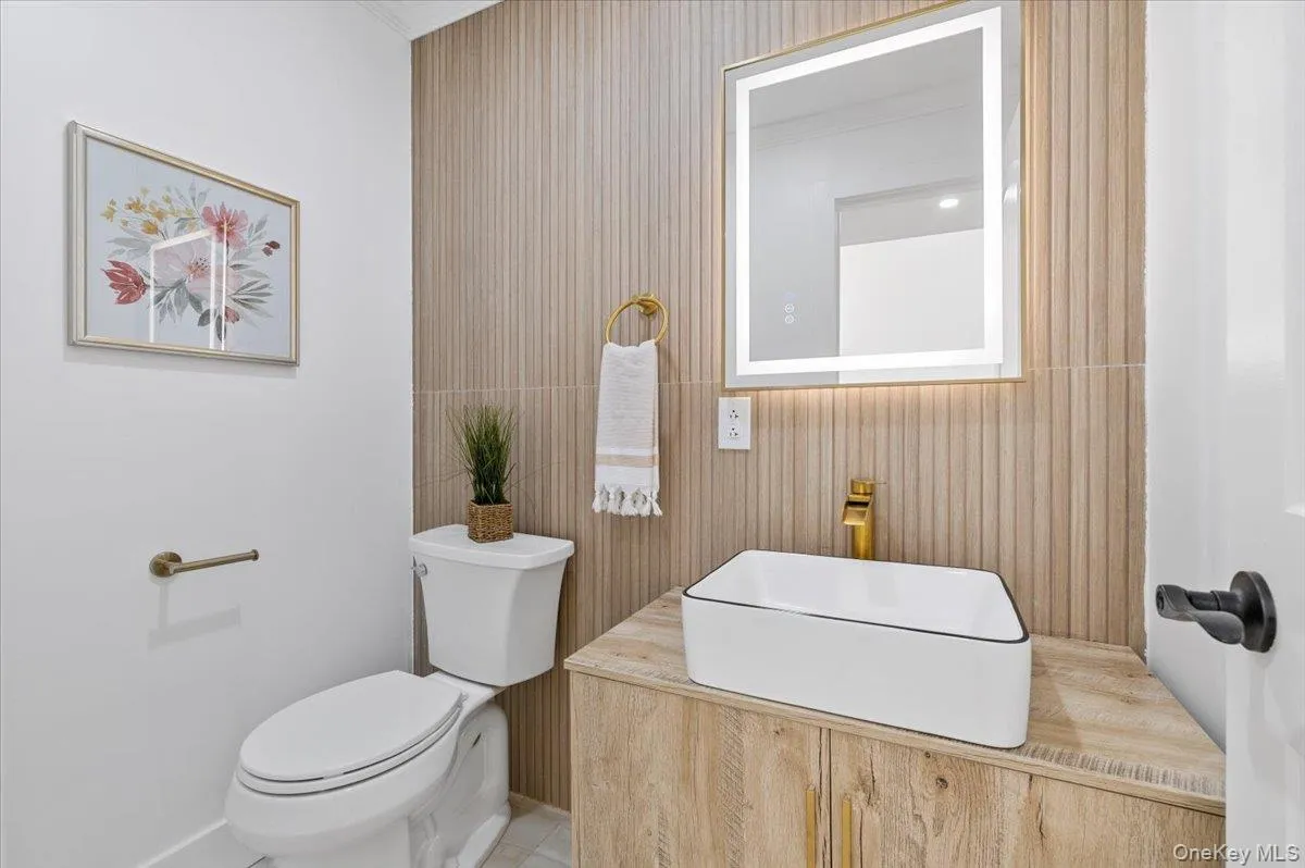 Half bathroom featuring toilet and a sink Half bathroom featuring toilet and a sink