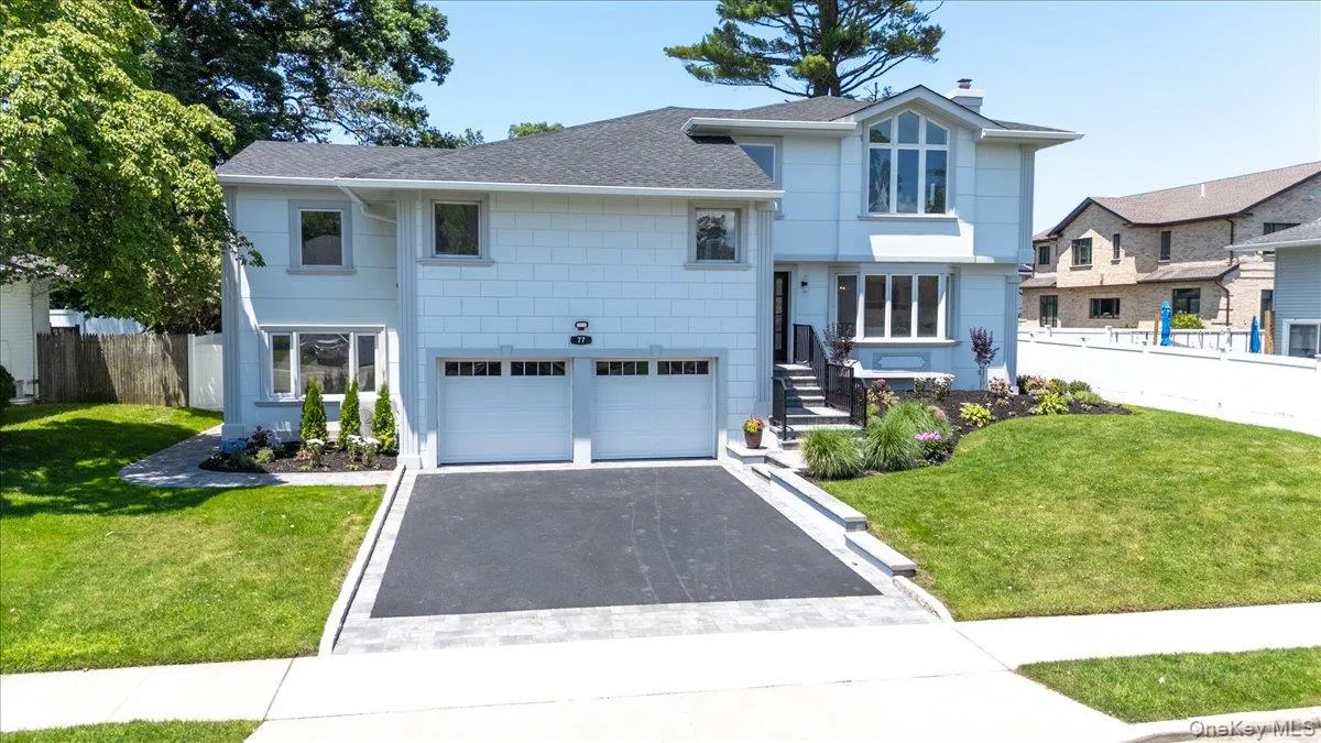 View of front of house featuring roof with shingles, driveway, an attached garage, and a chimney View of front of house featuring roof with shingles, driveway, an attached garage, and a chimney