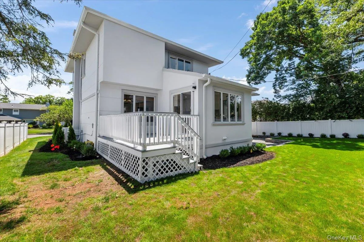 Rear view of property featuring a wooden deck and stucco siding Rear view of property featuring a wooden deck and stucco siding