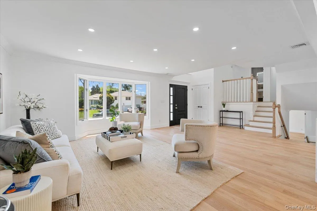 Living room with light wood-style flooring, stairs, recessed lighting, and ornamental molding Living room with light wood-style flooring, stairs, recessed lighting, and ornamental molding