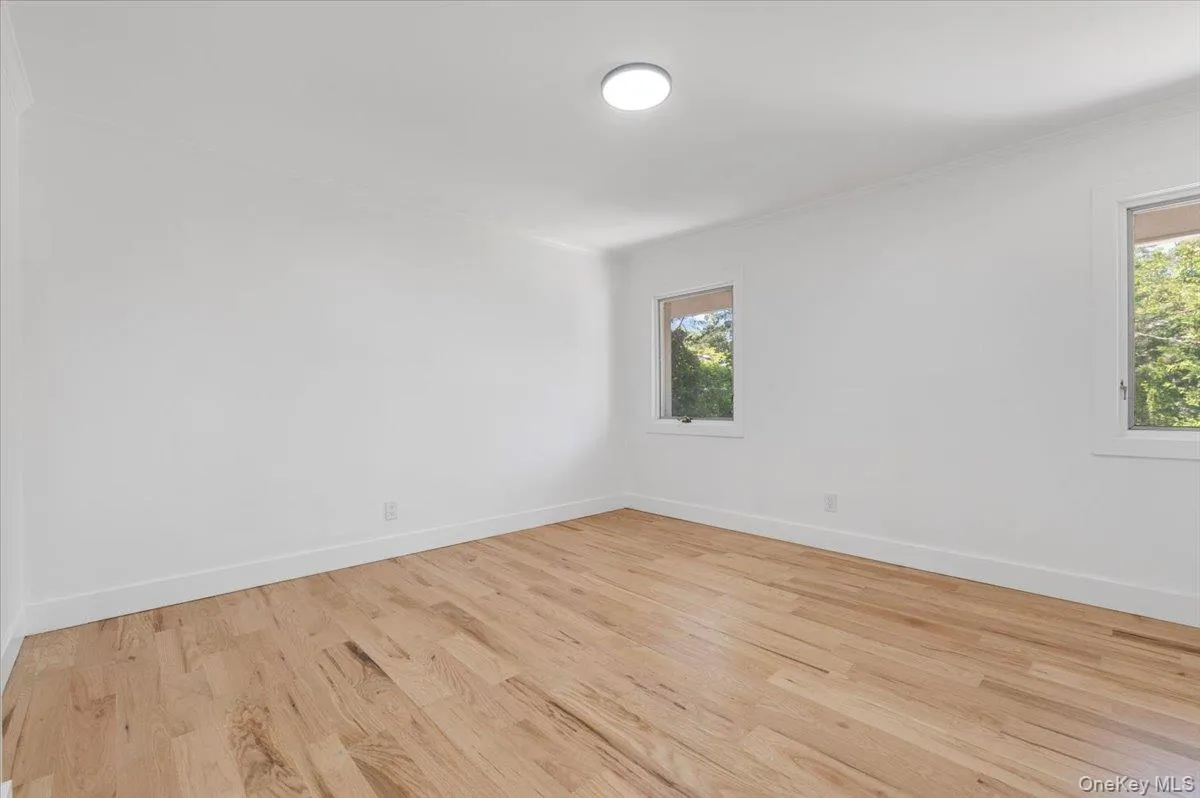 Unfurnished room featuring wood finished floors and ornamental molding Unfurnished room featuring wood finished floors and ornamental molding