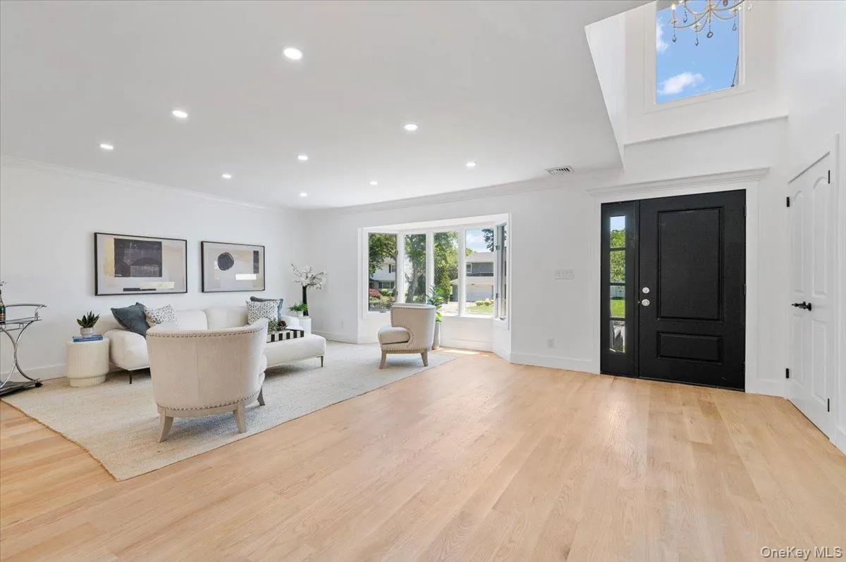 Foyer featuring light wood-style flooring, crown molding, recessed lighting, and a chandelier Foyer featuring light wood-style flooring, crown molding, recessed lighting, and a chandelier