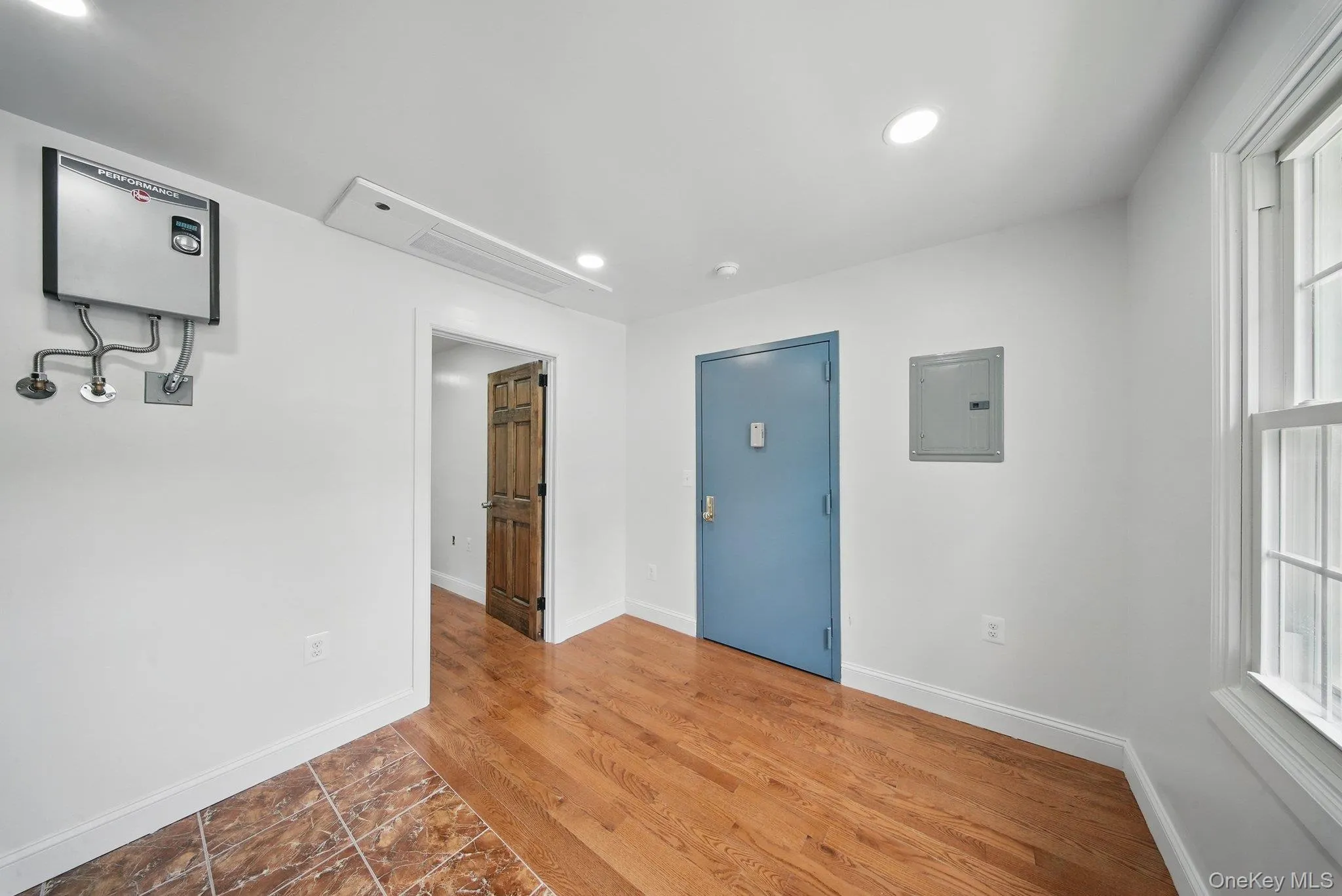 Unfurnished room with electric panel, baseboards, recessed lighting, and wood finished floors Unfurnished room with electric panel, baseboards, recessed lighting, and wood finished floors