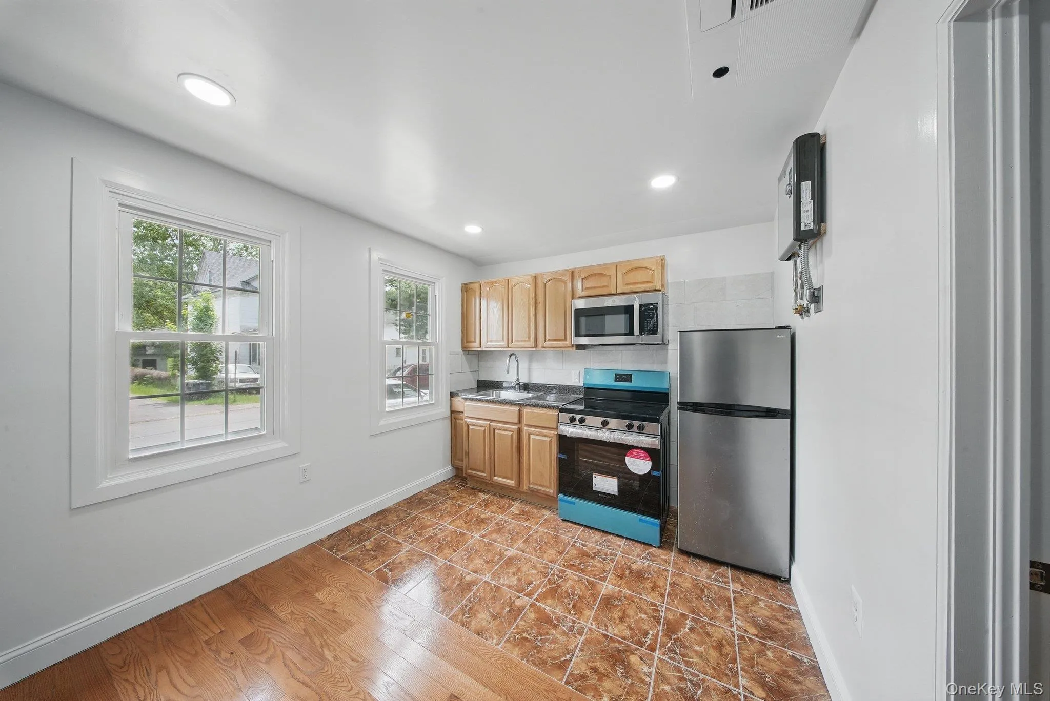 Kitchen with appliances with stainless steel finishes, a sink, light brown cabinets, and recessed lighting Kitchen with appliances with stainless steel finishes, a sink, light brown cabinets, and recessed lighting