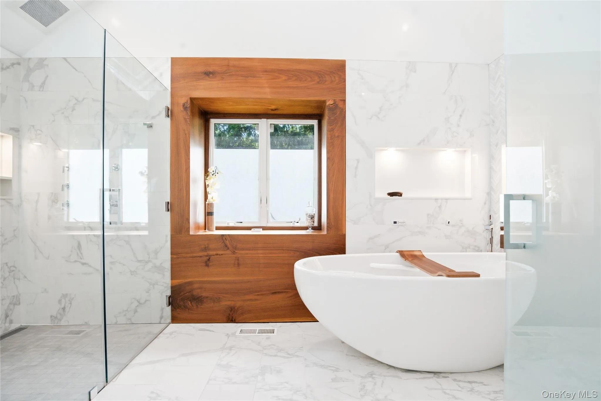 Elegant freestanding soaking tub framed by custom millwork and abundant natural light. Elegant freestanding soaking tub framed by custom millwork and abundant natural light.