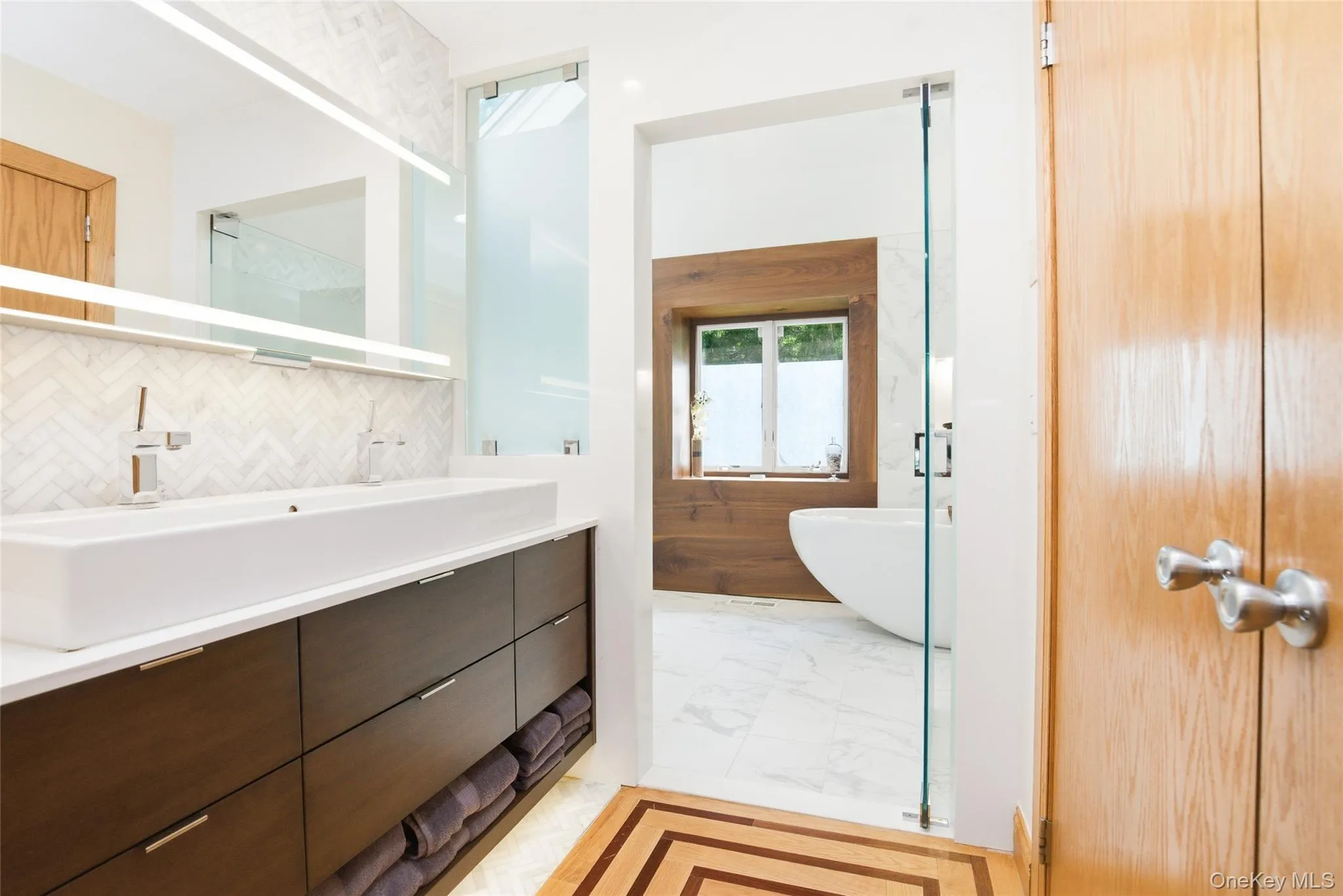 Primary Bathroom: Luxuriously renovated primary bath showcasing a custom double vanity, elegant marble finishes, premium fixtures, and abundant natural light, creating a true spa-like retreat. Primary Bathroom: Luxuriously renovated primary bath showcasing a custom double vanity, elegant marble finishes, premium fixtures, and abundant natural light, creating a true spa-like retreat.