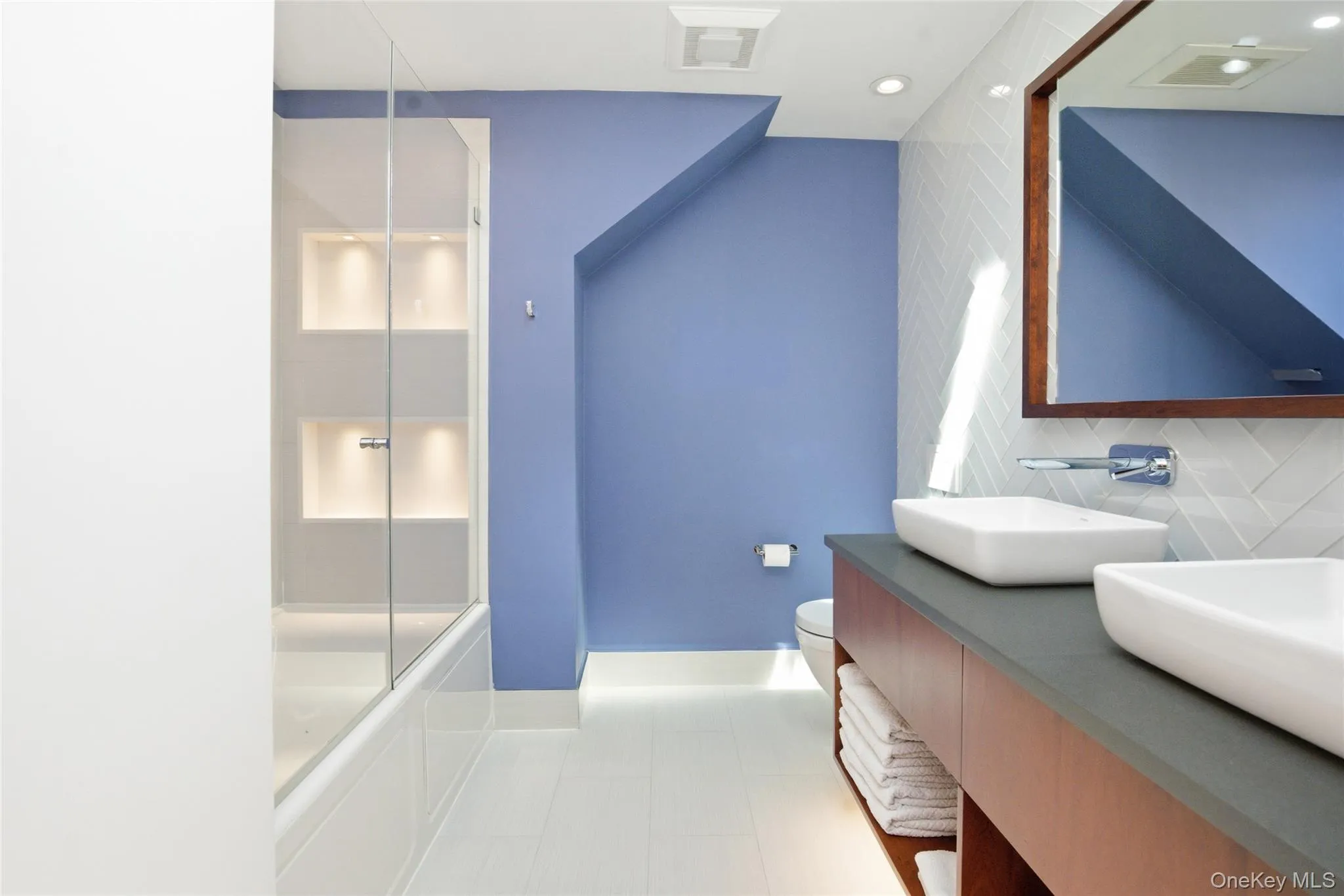 Second-Floor Bathroom: Beautifully renovated bath featuring a custom double vanity with vessel sinks, premium fixtures, and thoughtfully integrated lighting details throughout. Second-Floor Bathroom: Beautifully renovated bath featuring a custom double vanity with vessel sinks, premium fixtures, and thoughtfully integrated lighting details throughout.