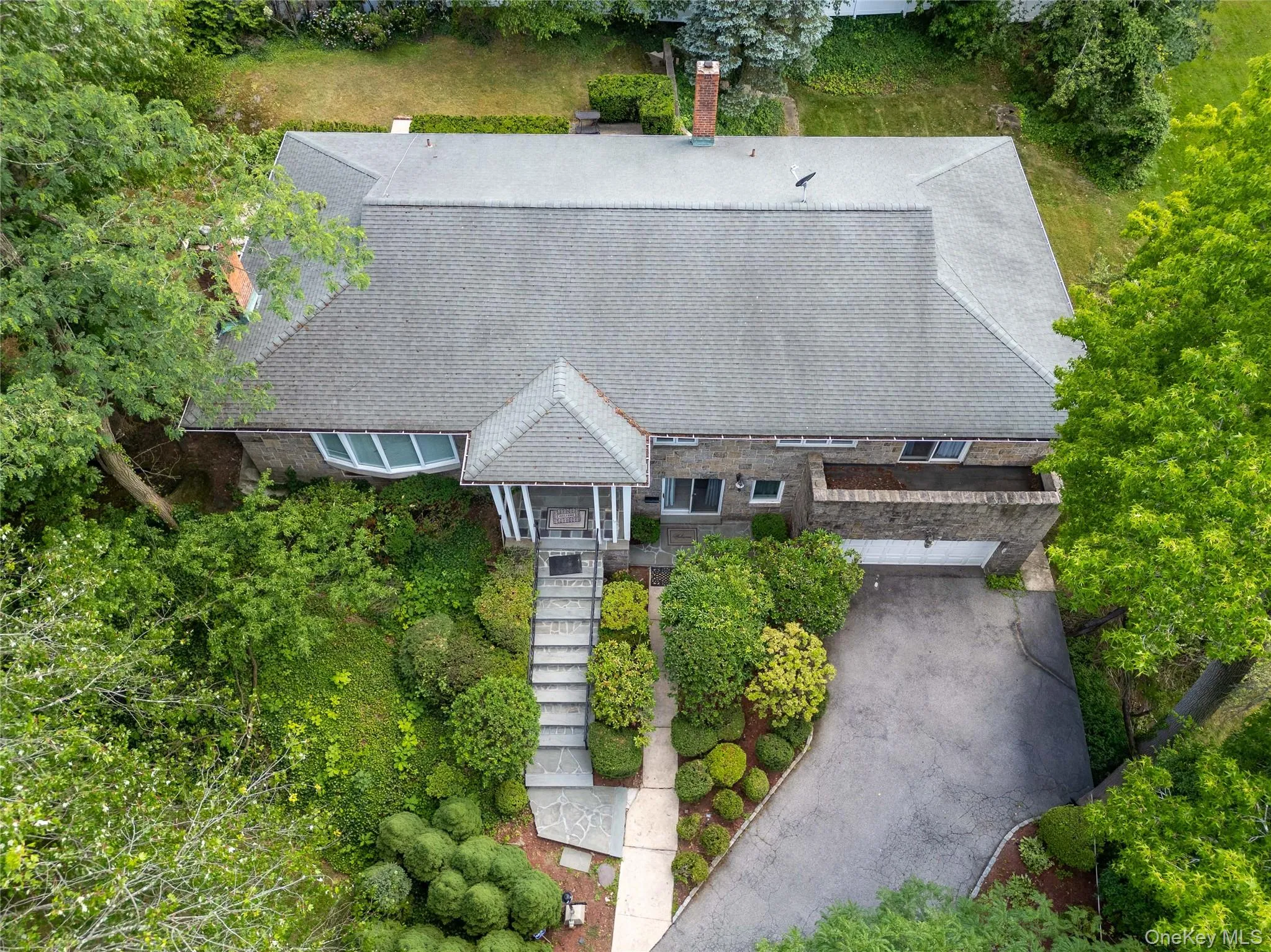 Drone shot of front entrance with covered portico, bay window, and gabled rooflines. Drone shot of front entrance with covered portico, bay window, and gabled rooflines.
