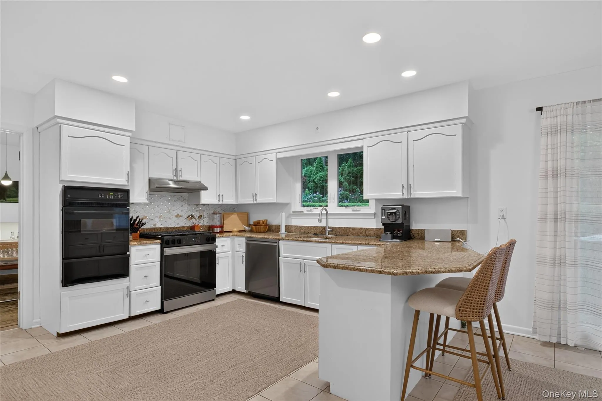 Bright kitchen featuring new stainless steel appliances and a peninsula with countertop seating. Bright kitchen featuring new stainless steel appliances and a peninsula with countertop seating.