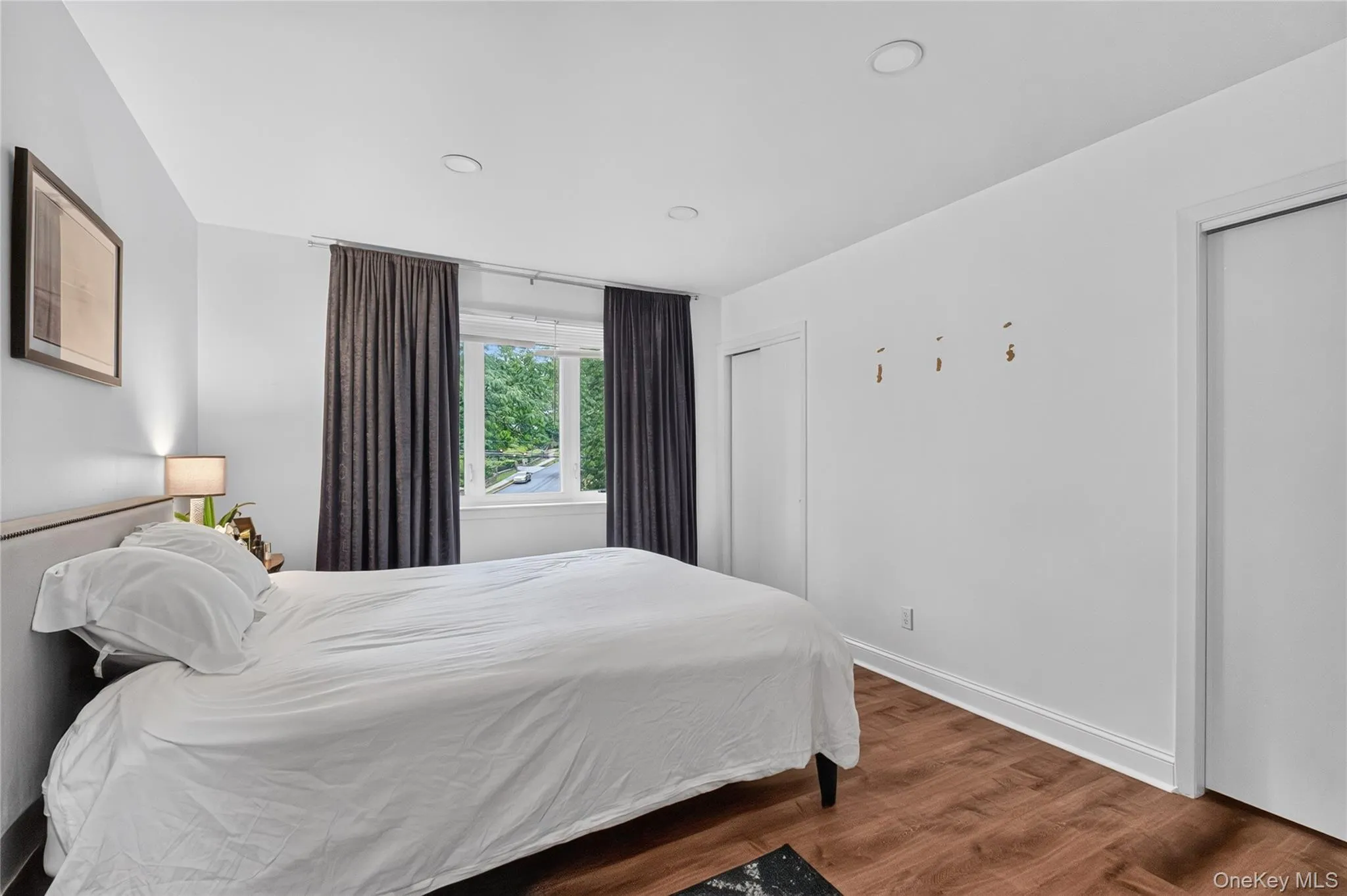 Bright room featuring wood-finish flooring, recessed lighting and 2 closets. Bright room featuring wood-finish flooring, recessed lighting and 2 closets.