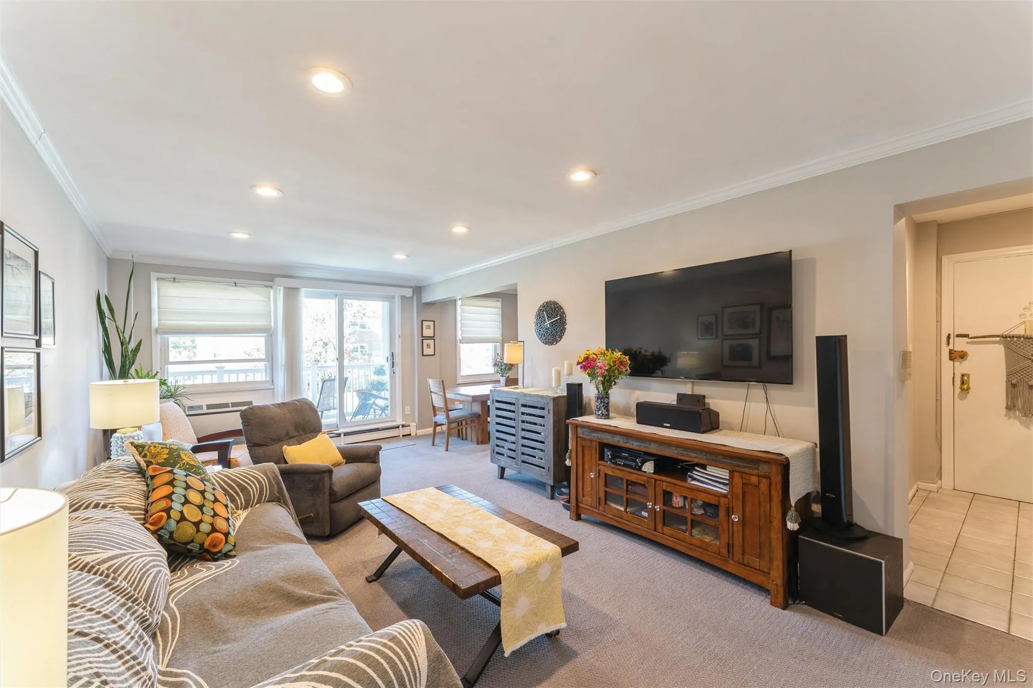 Carpeted living room featuring crown molding and recessed lighting. Carpeted living room featuring crown molding and recessed lighting.