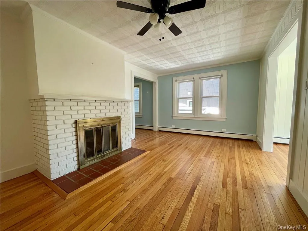 Living Room leading to both Sunroom and Dining Room, hardwood floors throughout and plenty of windows and sunlight Living Room leading to both Sunroom and Dining Room, hardwood floors throughout and plenty of windows and sunlight