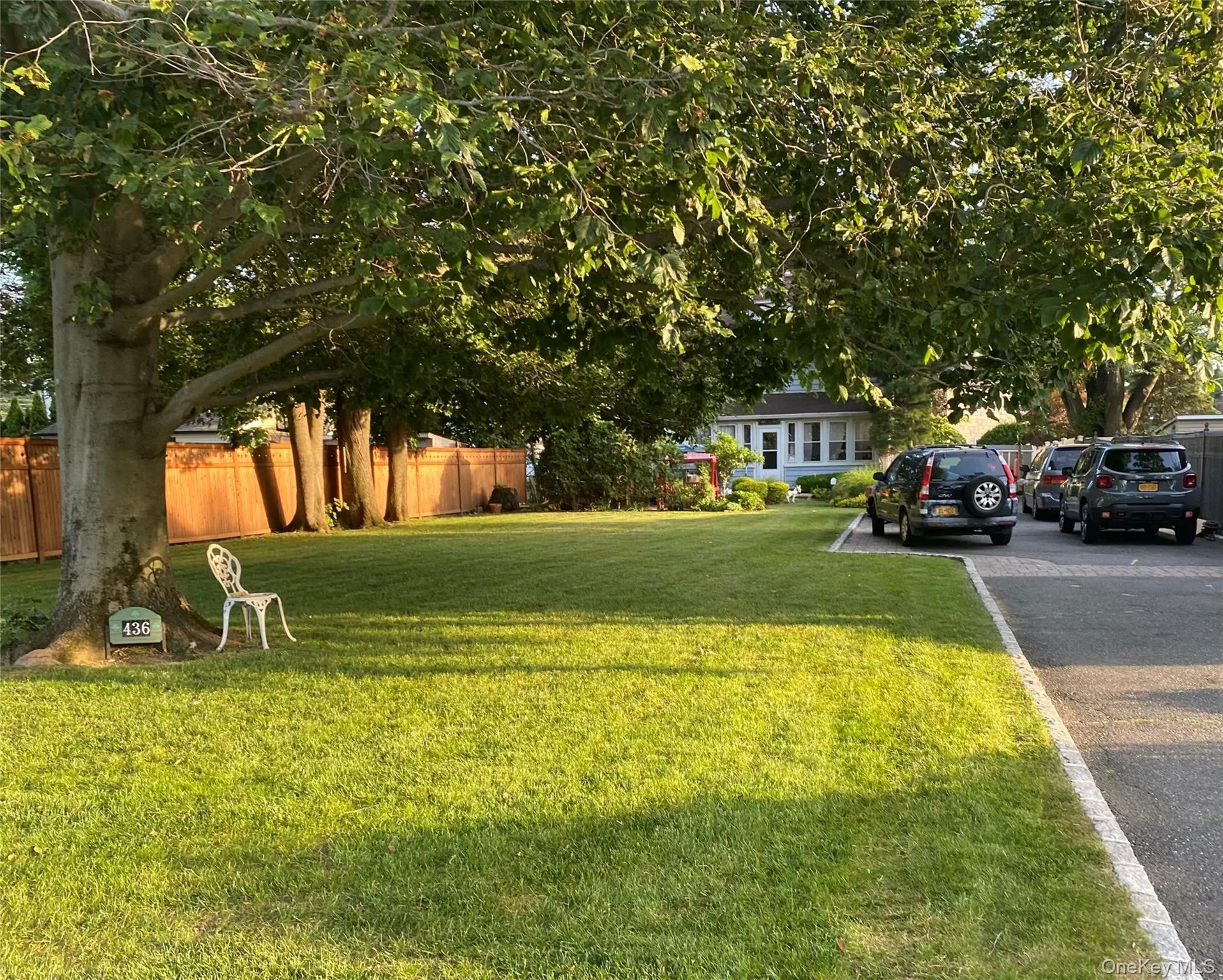 Sprawling front yard with paved parking area Sprawling front yard with paved parking area