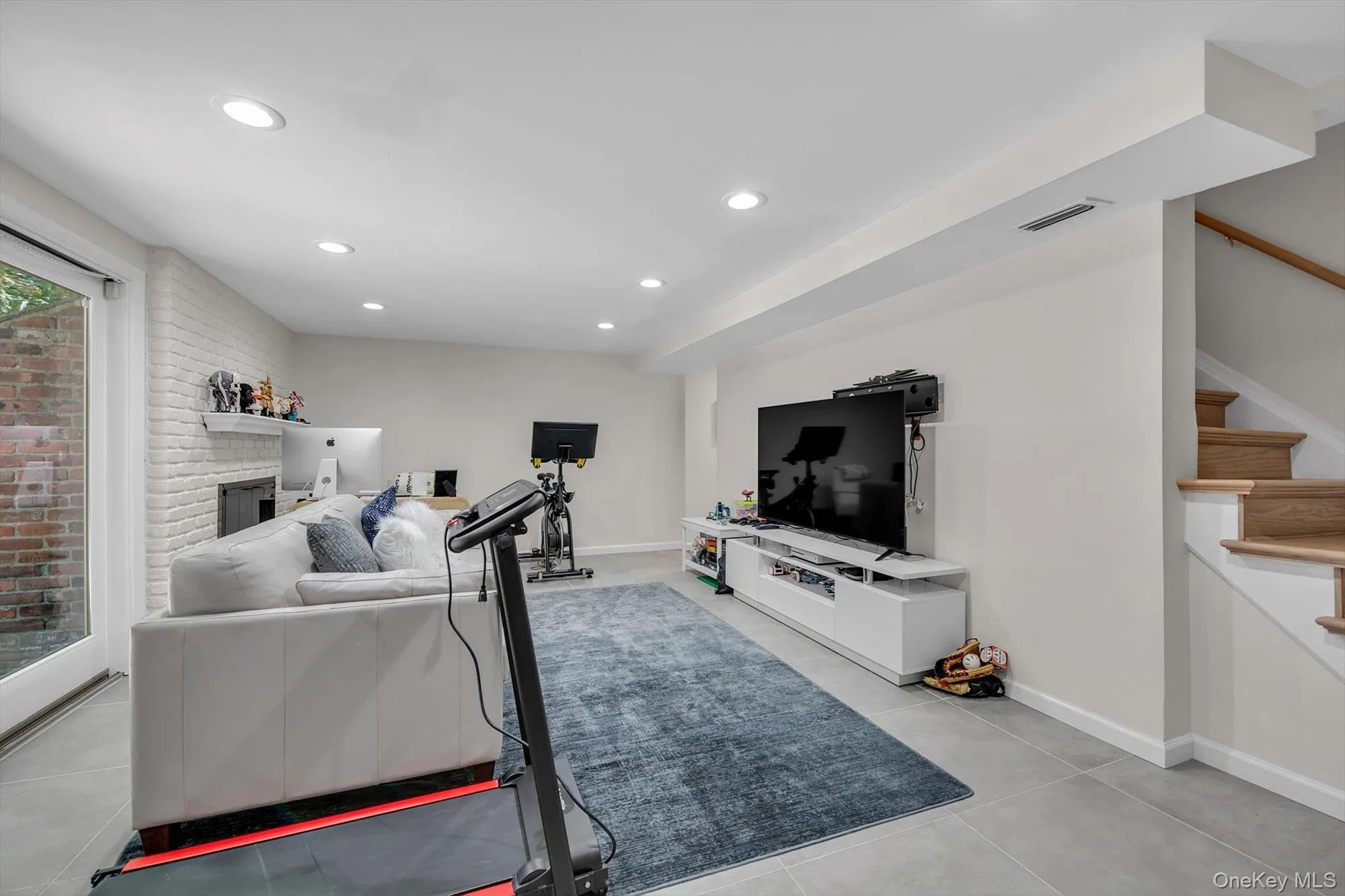 The renovated lower level provides additional living space centered around a charming wood-burning fireplace, with new stairs, ceramic tile flooring, and sliding doors leading to a private outdoor retreat. The renovated lower level provides additional living space centered around a charming wood-burning fireplace, with new stairs, ceramic tile flooring, and sliding doors leading to a private outdoor retreat.
