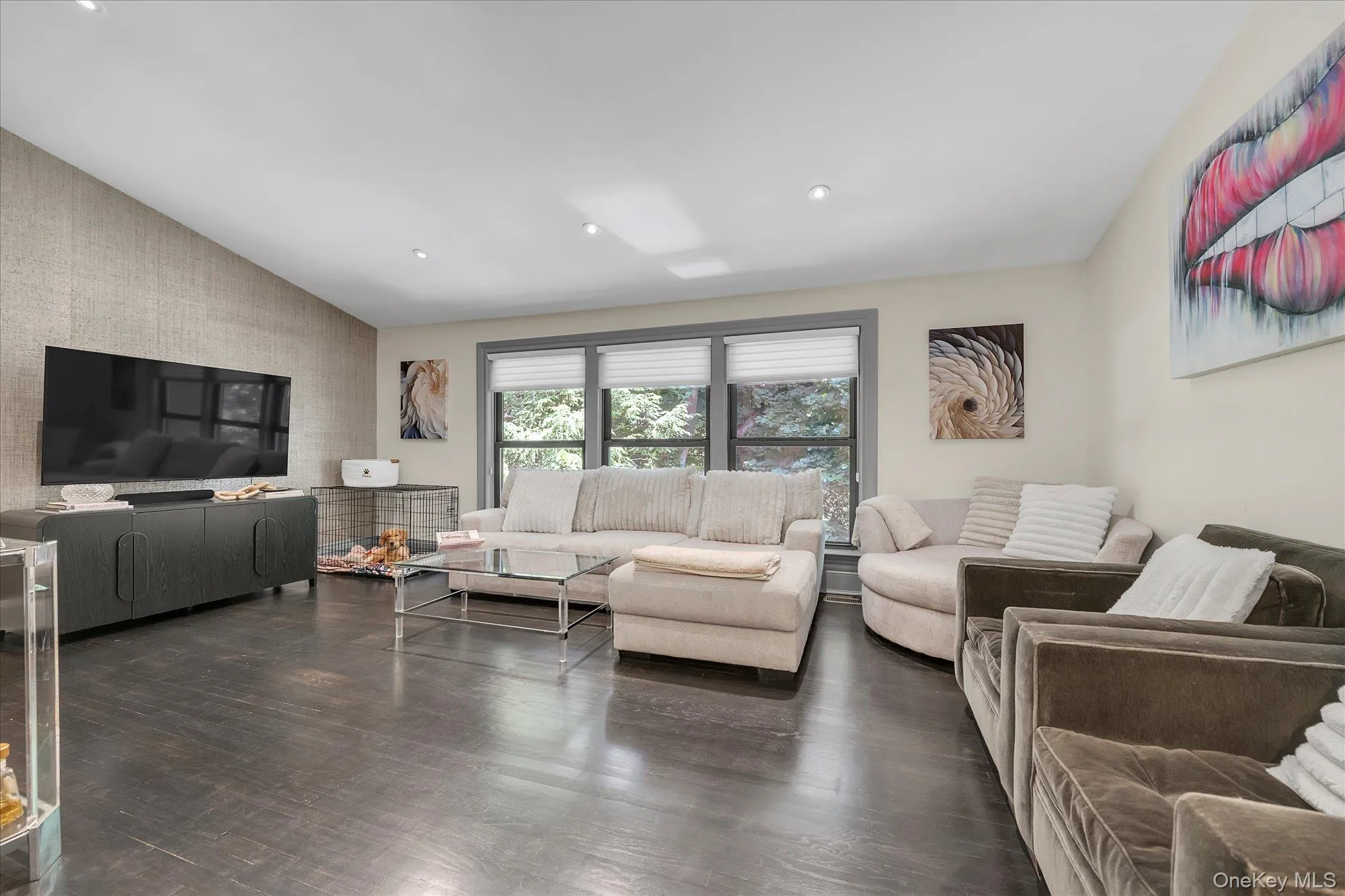 The spacious living room is highlighted by a wall of windows that creates a bright, airy atmosphere. The spacious living room is highlighted by a wall of windows that creates a bright, airy atmosphere.