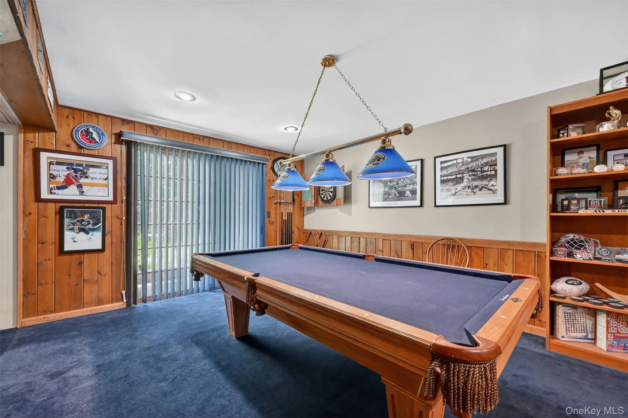 Recreation room featuring wood paneling, recessed lighting, a built-in shelving units. Recreation room featuring wood paneling, recessed lighting, a built-in shelving units.