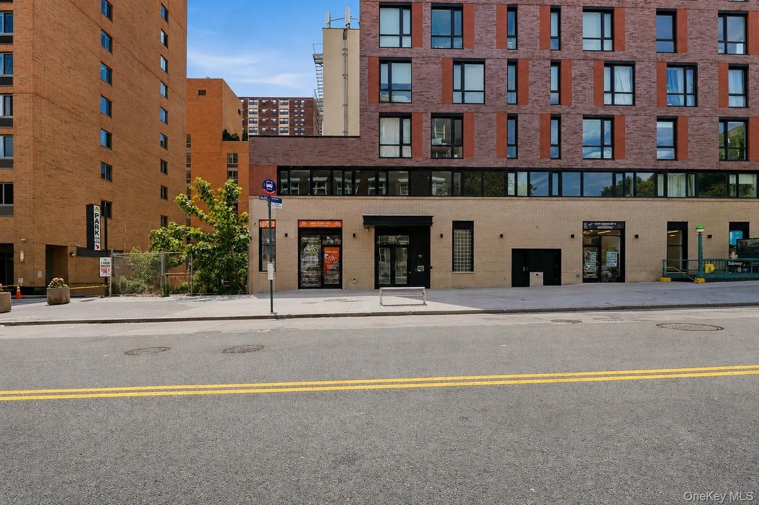 Modern brick and block facade building with ground-level retail spaces and upper-level residences Modern brick and block facade building with ground-level retail spaces and upper-level residences