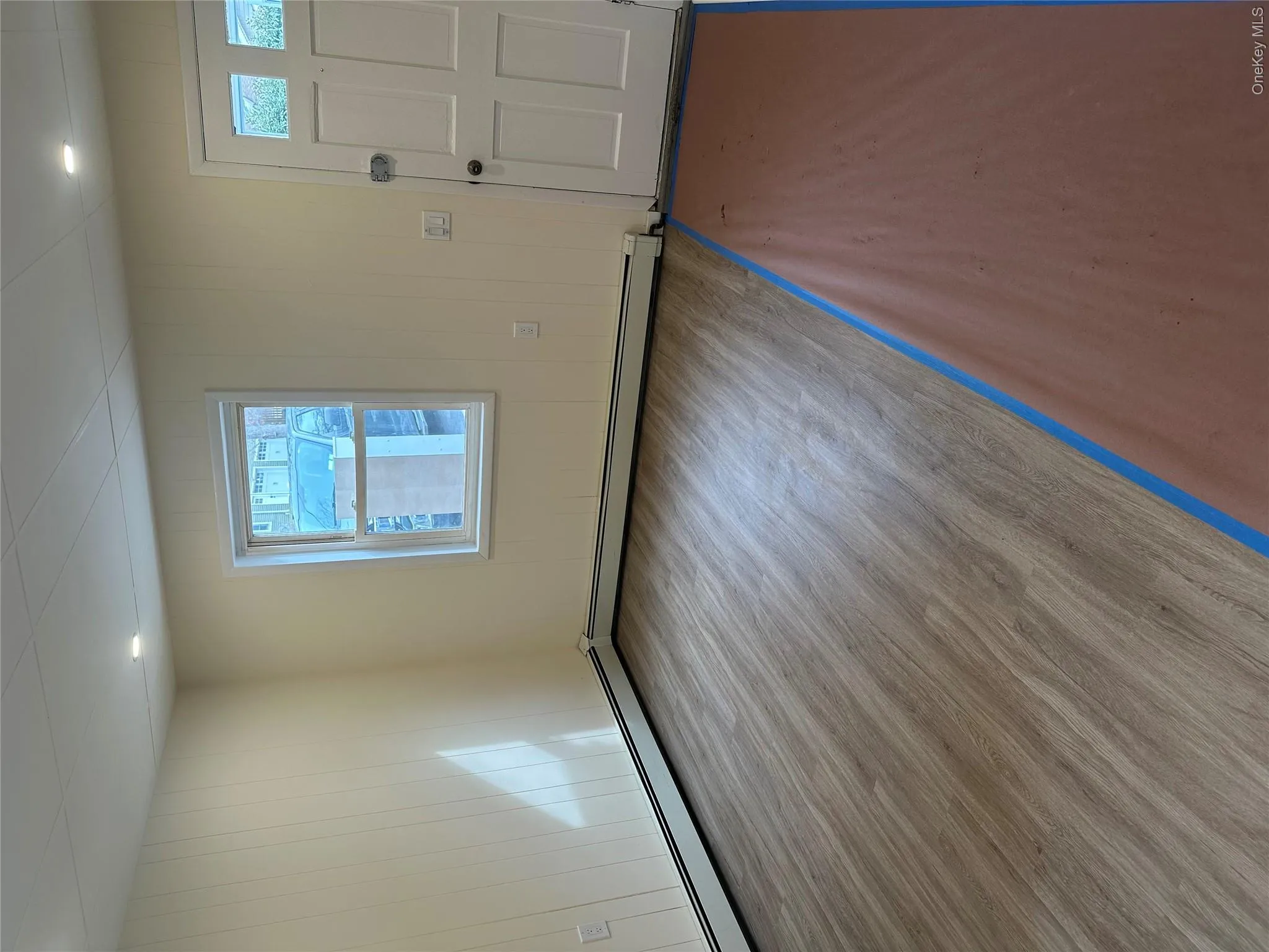 Foyer with a baseboard heating unit and light hardwood / wood-style floors Foyer with a baseboard heating unit and light hardwood / wood-style floors
