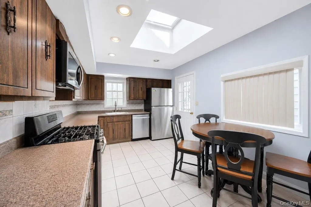 Kitchen featuring a skylight, recessed lighting, and tile flooring Kitchen featuring a skylight, recessed lighting, and tile flooring