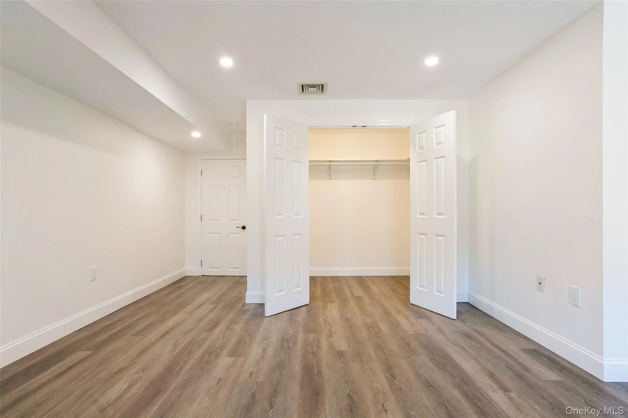 Unfurnished bedroom featuring recessed lighting, baseboards, and wood finished floors Unfurnished bedroom featuring recessed lighting, baseboards, and wood finished floors
