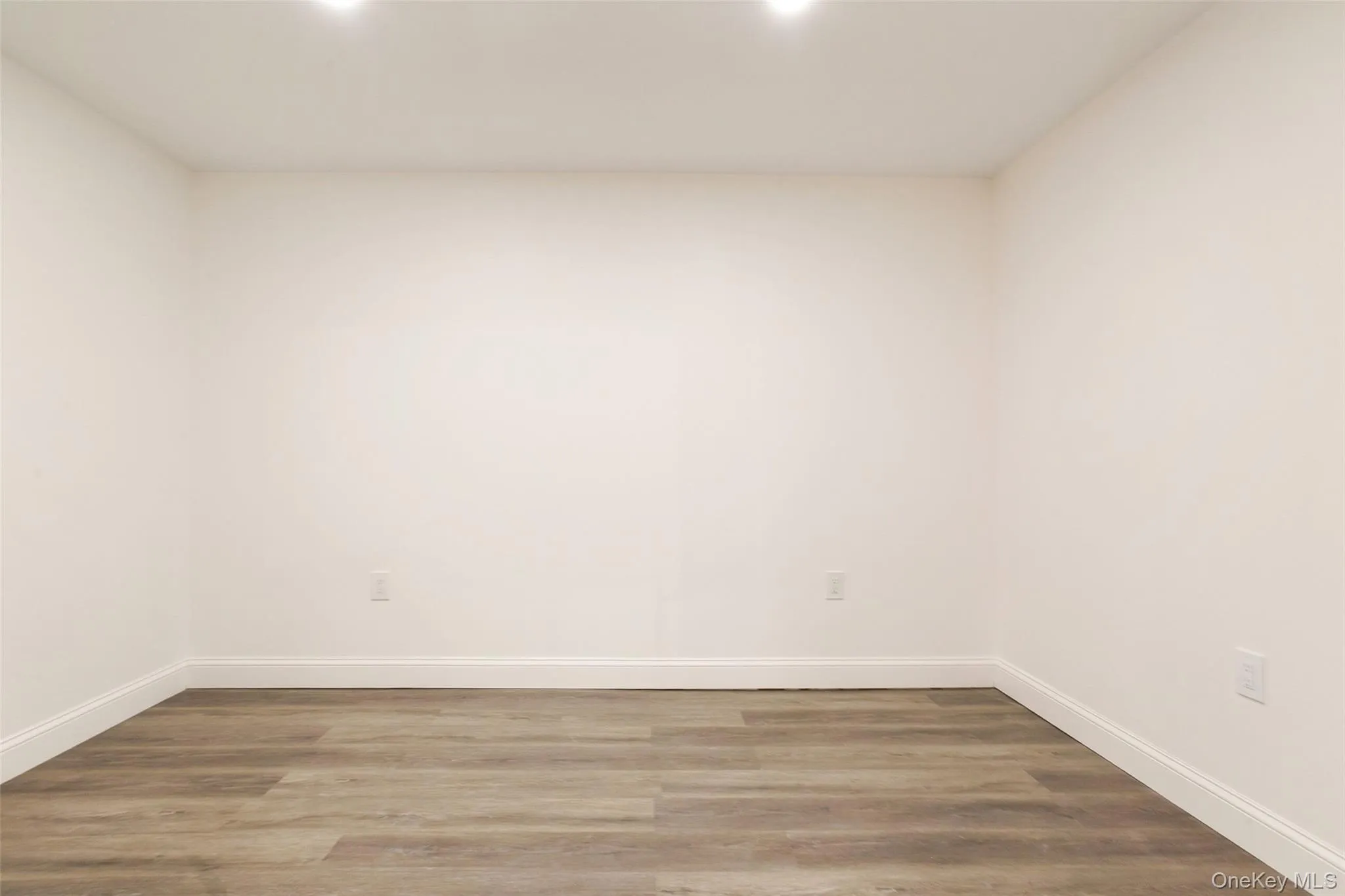 Unfurnished room with baseboards and wood finished floors Unfurnished room with baseboards and wood finished floors
