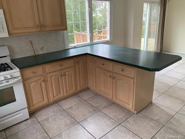 View on other side of counter of dining area and sliders out to deck View on other side of counter of dining area and sliders out to deck