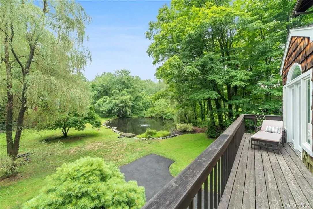 Wooden terrace featuring a water view and a lawn Wooden terrace featuring a water view and a lawn
