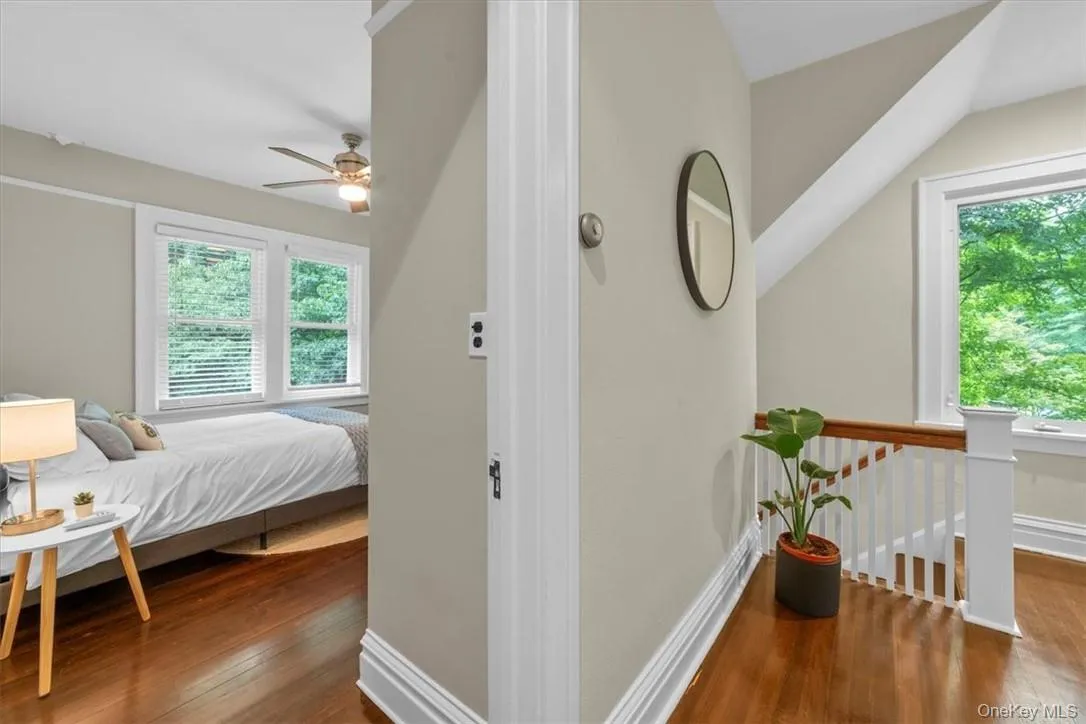 Bedroom with dark hardwood / wood-style floors, lofted ceiling, multiple windows, and ceiling fan Bedroom with dark hardwood / wood-style floors, lofted ceiling, multiple windows, and ceiling fan