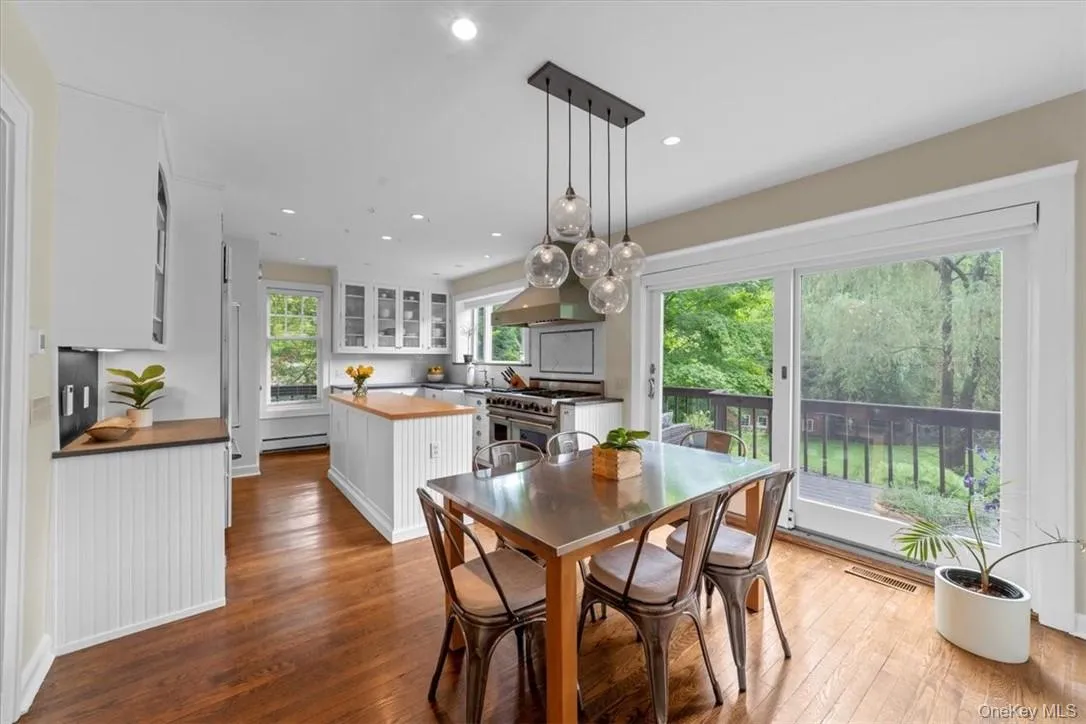 Dining space featuring sink, a baseboard heating unit, and hardwood / wood-style floors Dining space featuring sink, a baseboard heating unit, and hardwood / wood-style floors