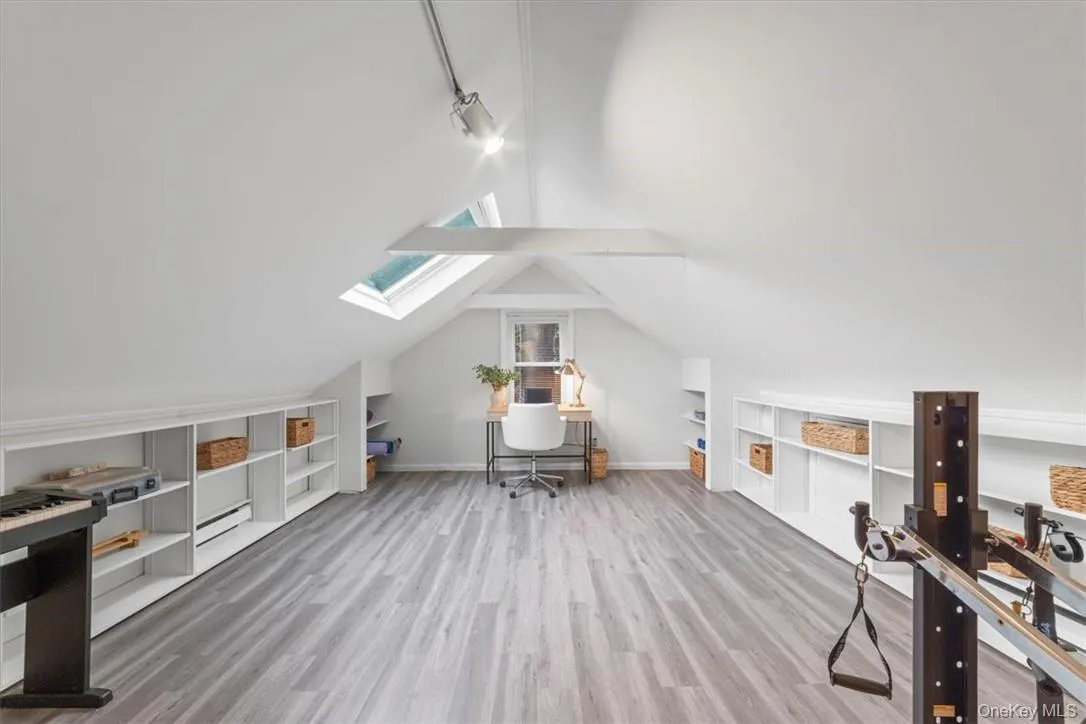 Office area with vaulted ceiling with skylight and wood-type flooring Office area with vaulted ceiling with skylight and wood-type flooring