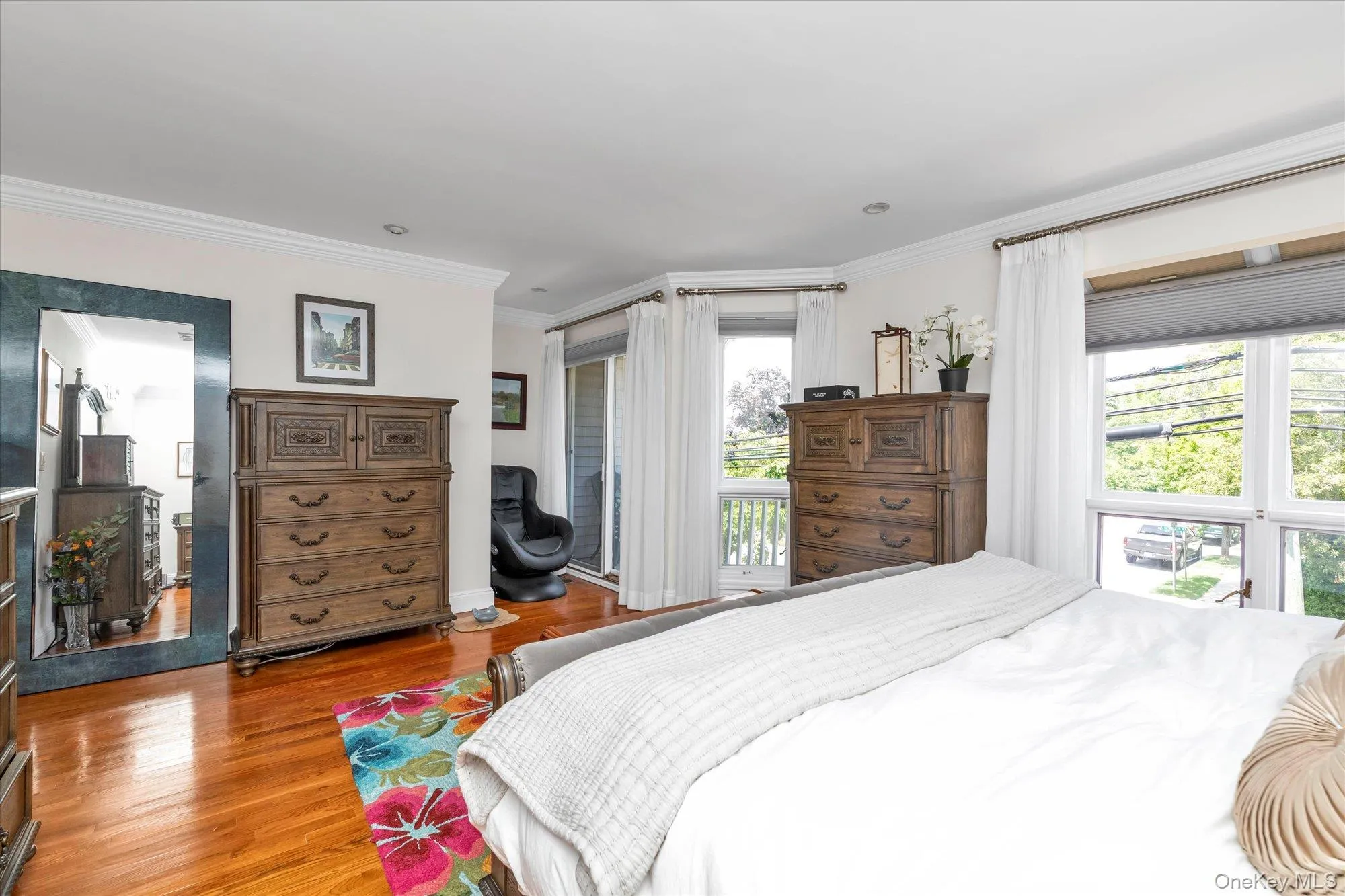 Spacious master featuring wood-finish flooring, white walls, and extensive crown molding Spacious master featuring wood-finish flooring, white walls, and extensive crown molding