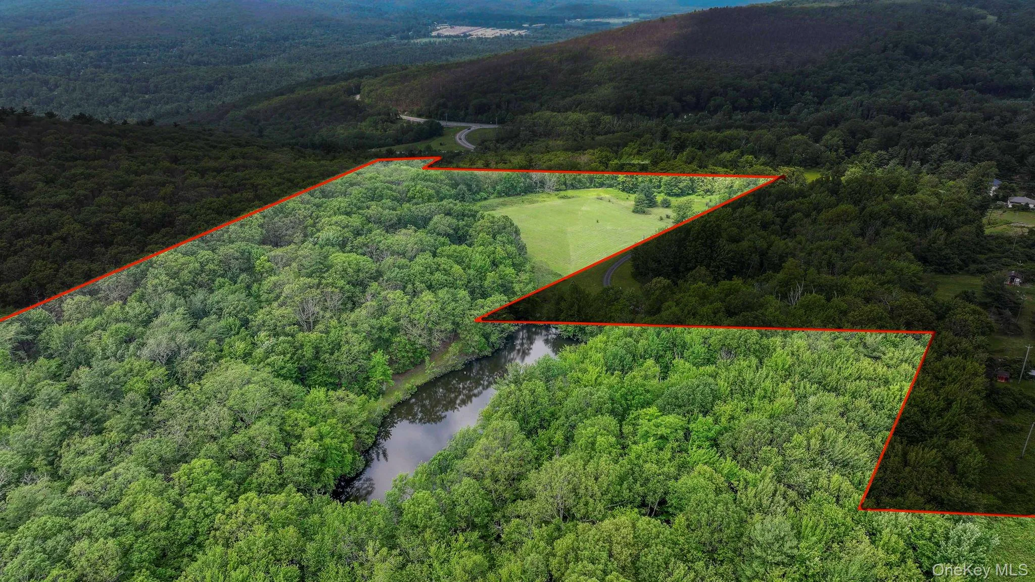 Aerial view of property and surrounding area with a heavily wooded area and property boundaries highlighted Aerial view of property and surrounding area with a heavily wooded area and property boundaries highlighted